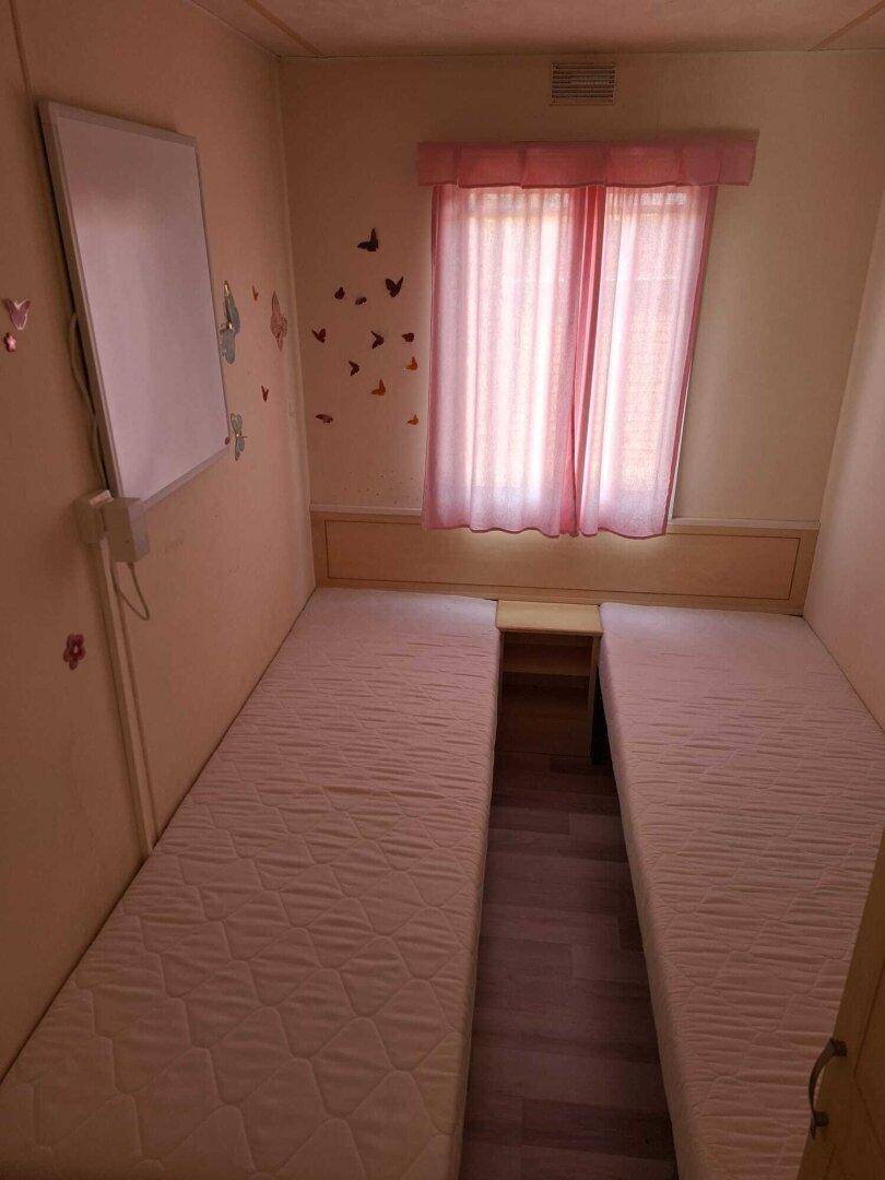 Schlafzimmer mit zwei Einzelbetten und einfacher Dekoration.