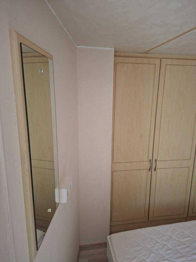 Schlafzimmer mit Einbauschränken und einem Wandspiegel.