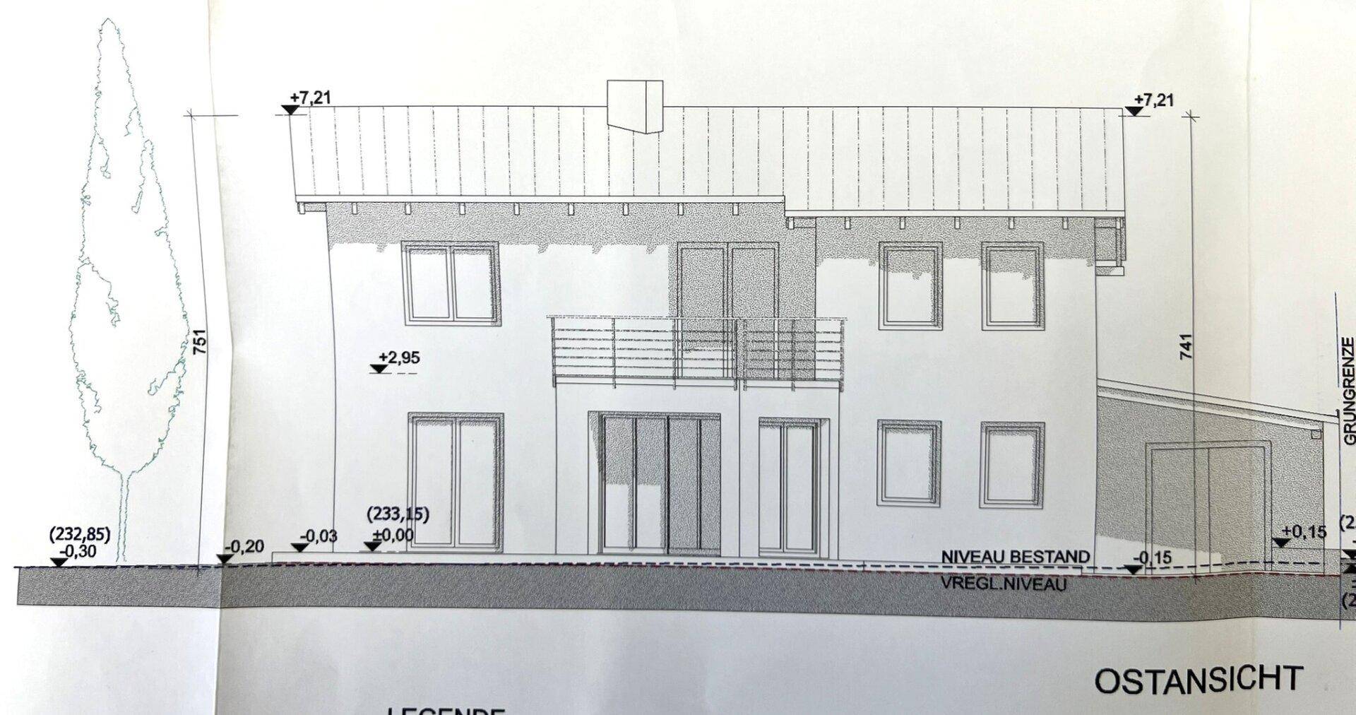 Ostansicht des Gebäudes mit Balkon und Terrasse, zeigt die Fassadengestaltung.
