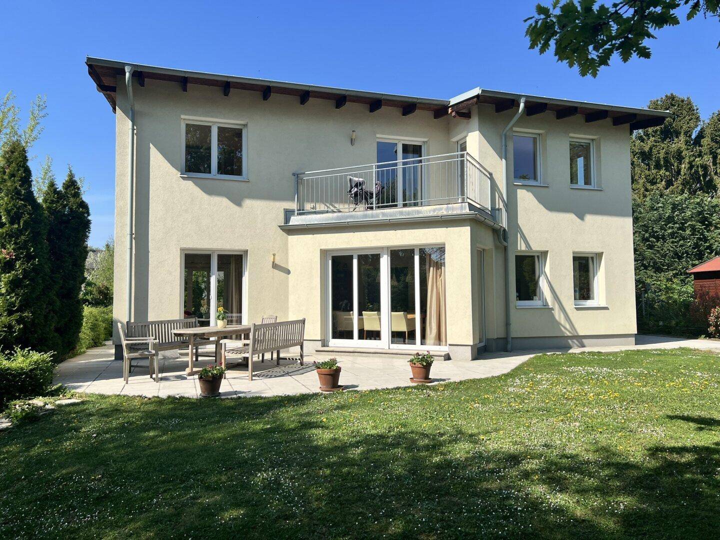 Geräumige Terrasse mit Gartenmöbeln und direktem Zugang zum gepflegten Rasenbereich des Hauses.