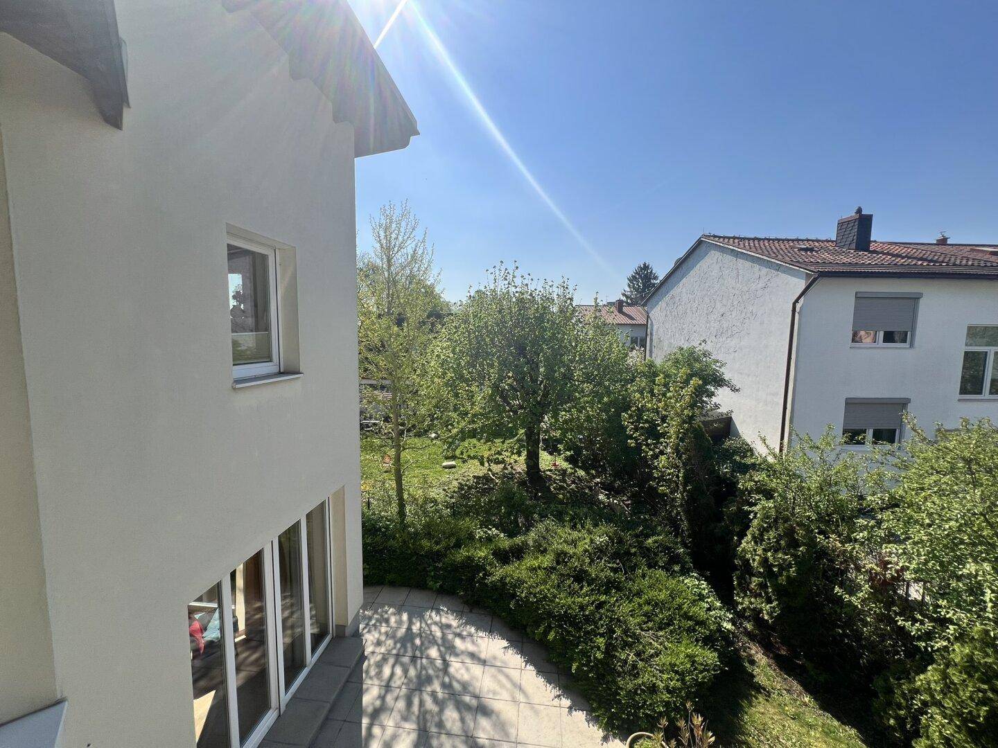 Blick von oben auf die Hausseite und den grünen Gartenbereich mit Nachbarhäusern.