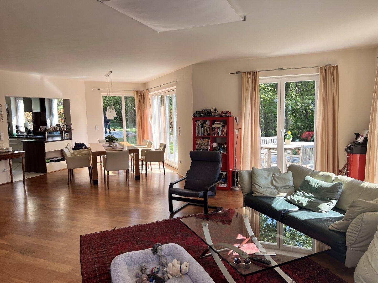 Offener Wohn- und Essbereich mit Holzboden und direktem Zugang zur Terrasse.