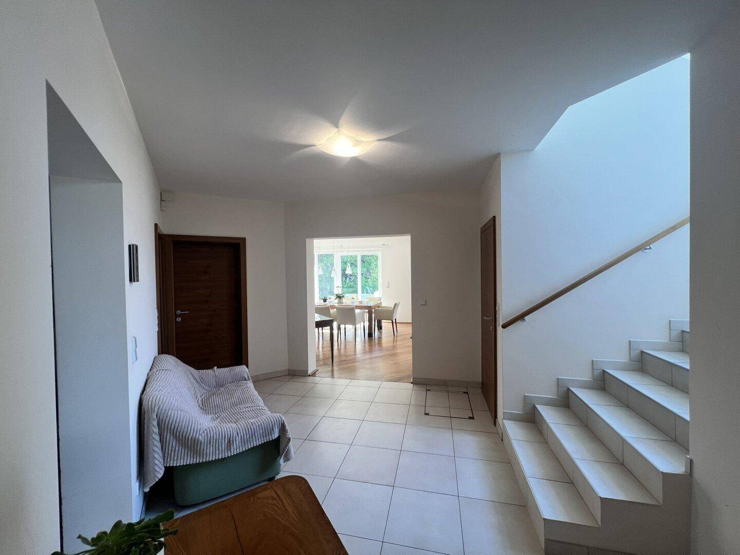 Geräumiger Flur mit Fliesenboden, Treppe und Zugang zu weiteren Räumen.