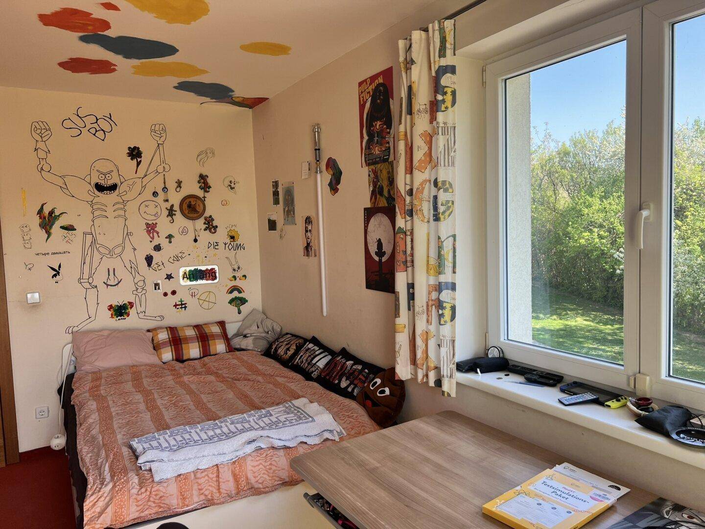 Schlafzimmer mit rotem Teppichboden, Bett und kreativer Wandgestaltung.