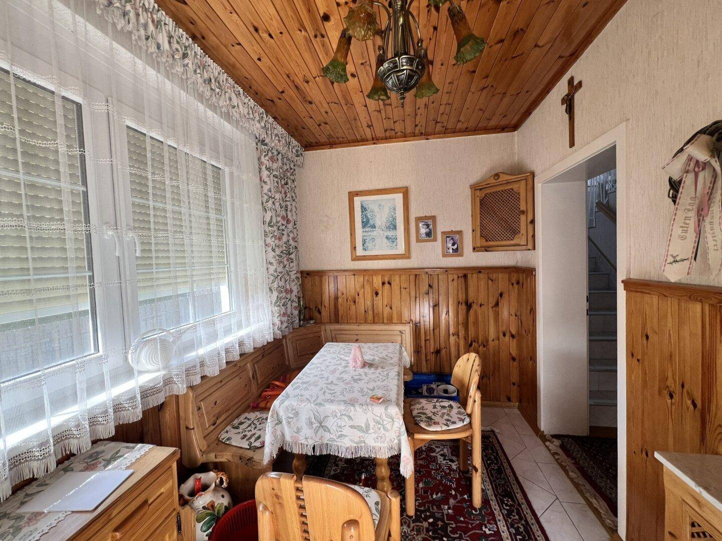 Rustikaler Essbereich mit Holztäfelung, eingebauter Sitzbank und traditionellem Mobiliar.
