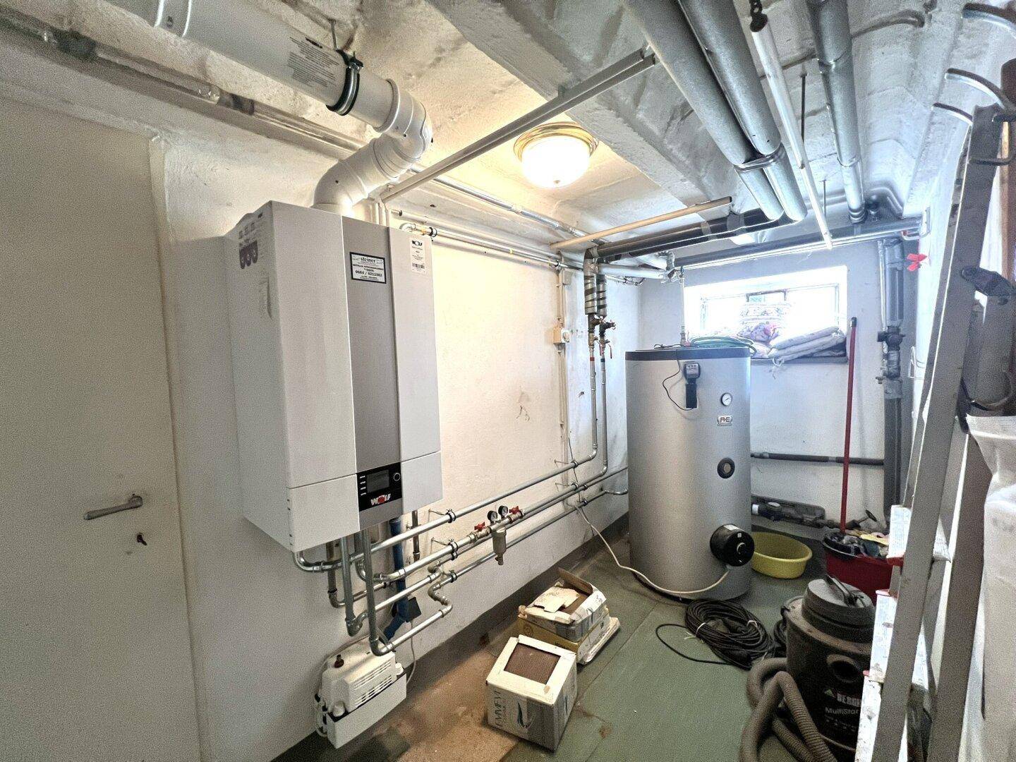 Heizungsraum im Untergeschoss mit moderner Heizungsanlage und Warmwasserspeicher.