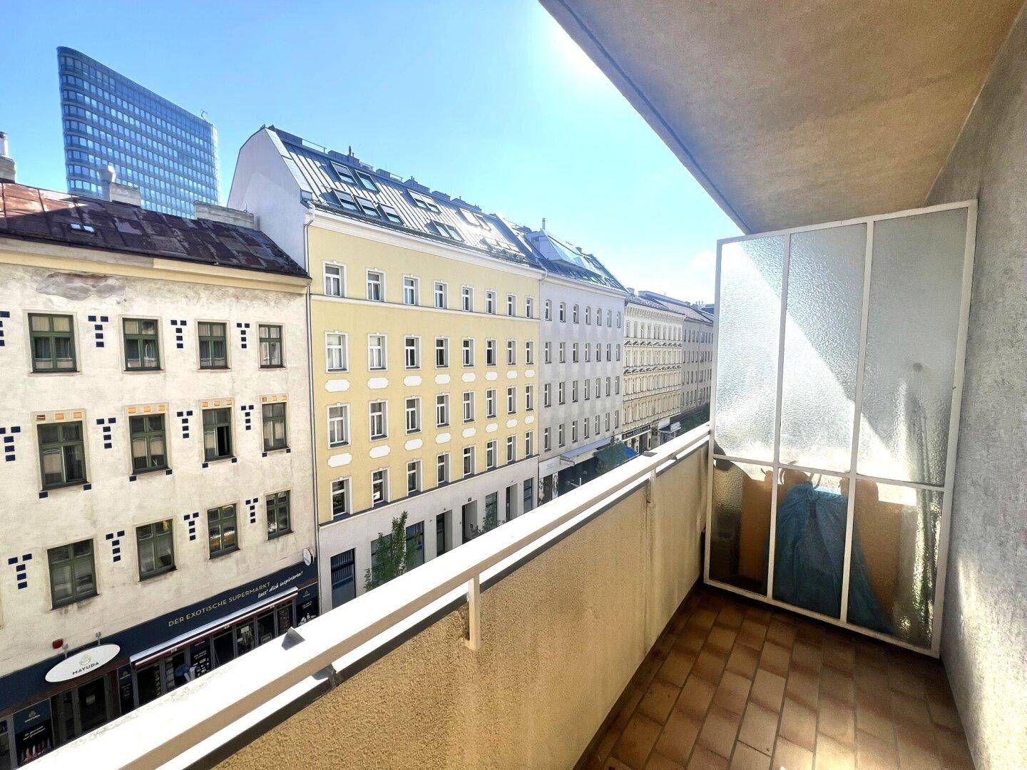 Geräumiger Balkon mit Fliesenboden und weitem Blick über die städtische Umgebung.