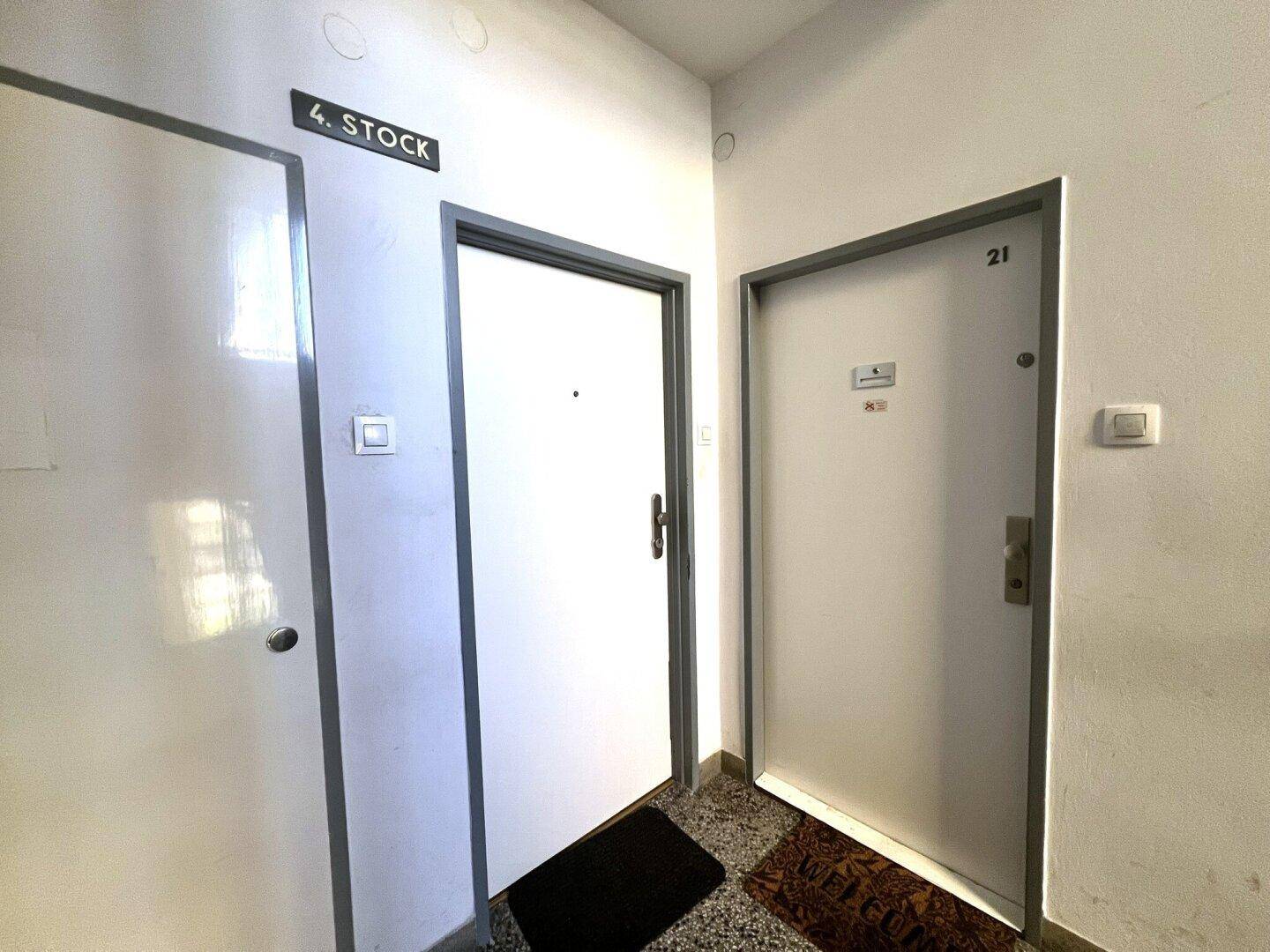 Eingangsbereich im 4. Stock mit zwei Wohnungstüren und Terrazzoboden.