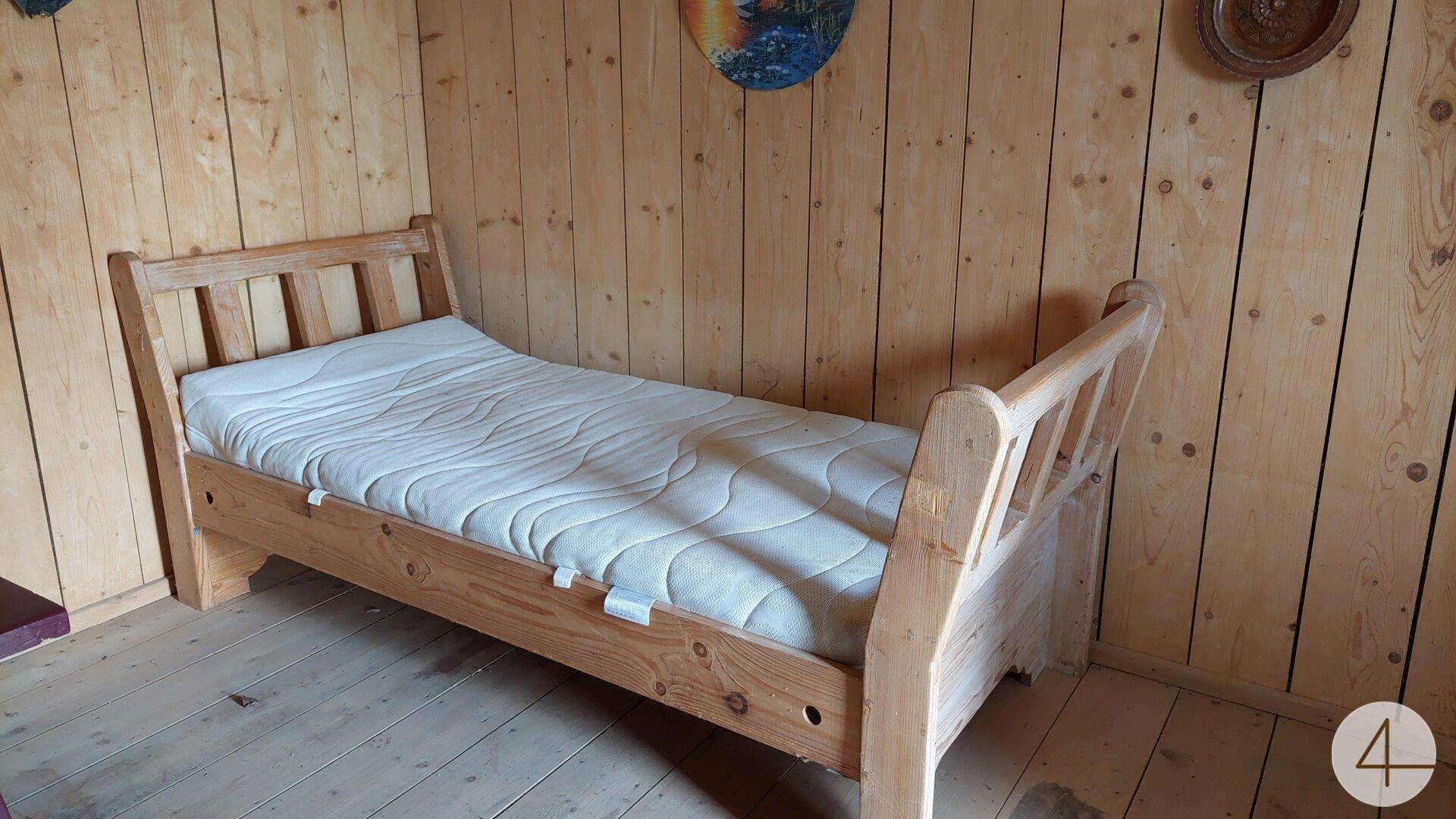 Gemütliches Schlafzimmer mit Holzverkleidung und einem Einzelbett im traditionellen Stil.