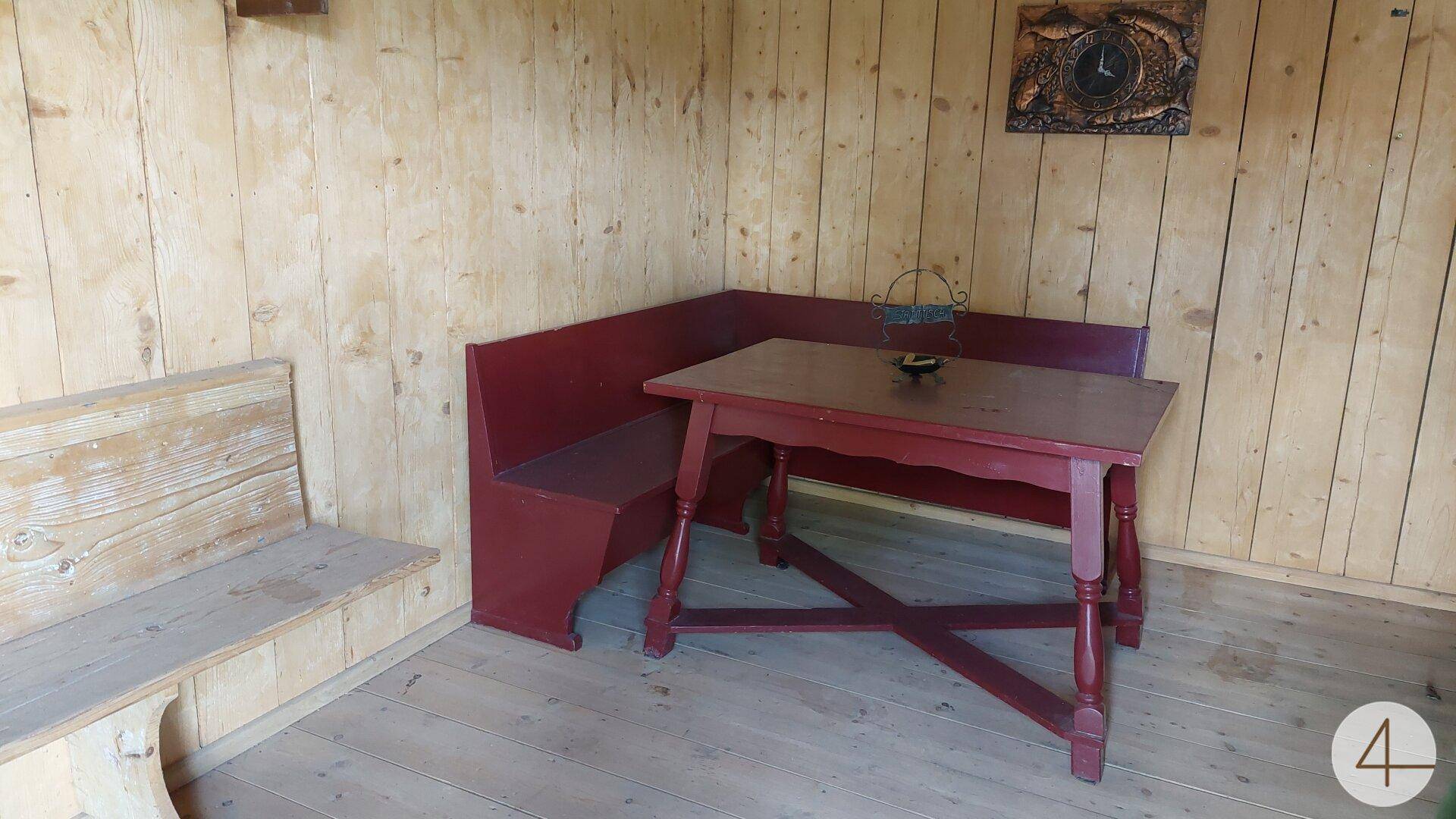 Rustikaler Essbereich mit Holzverkleidung und roten Holzmöbeln, traditionell eingerichtet.