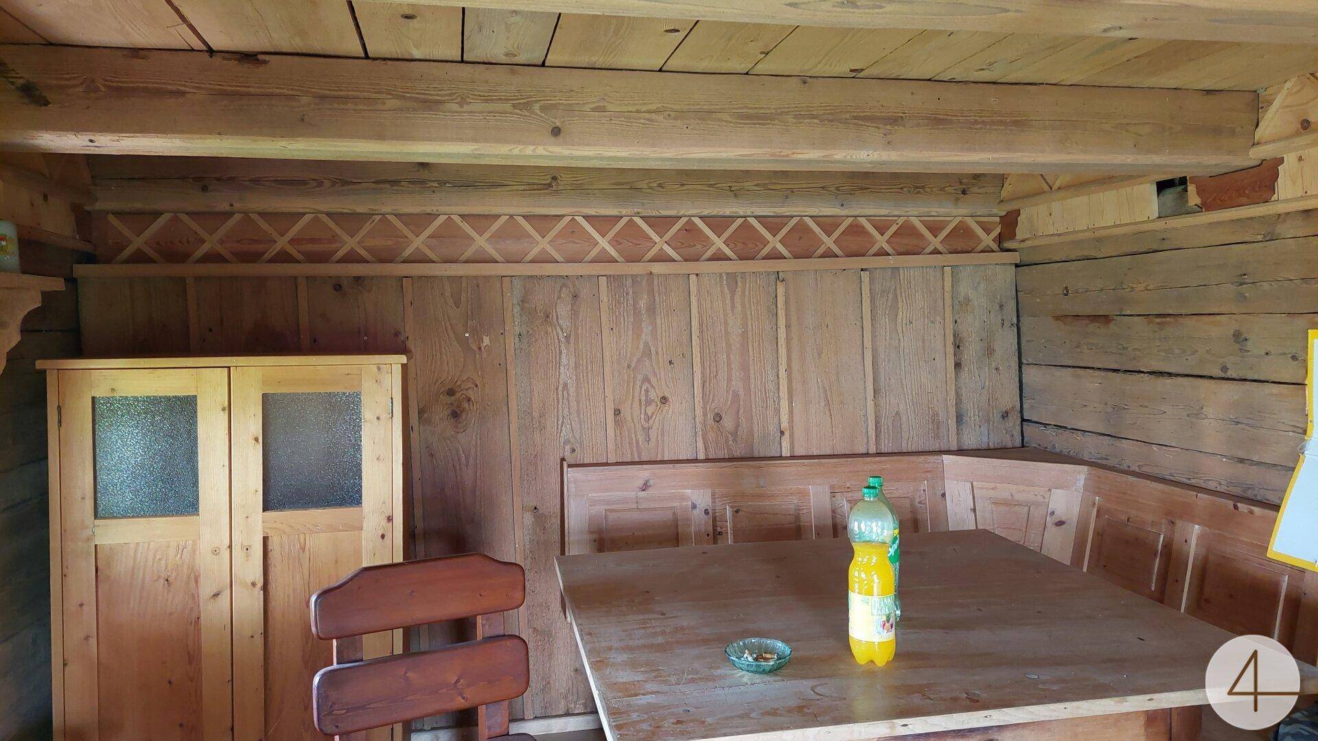Traditioneller Essbereich mit Holzverkleidung, Holztisch und Bänken, gemütlich eingerichtet.