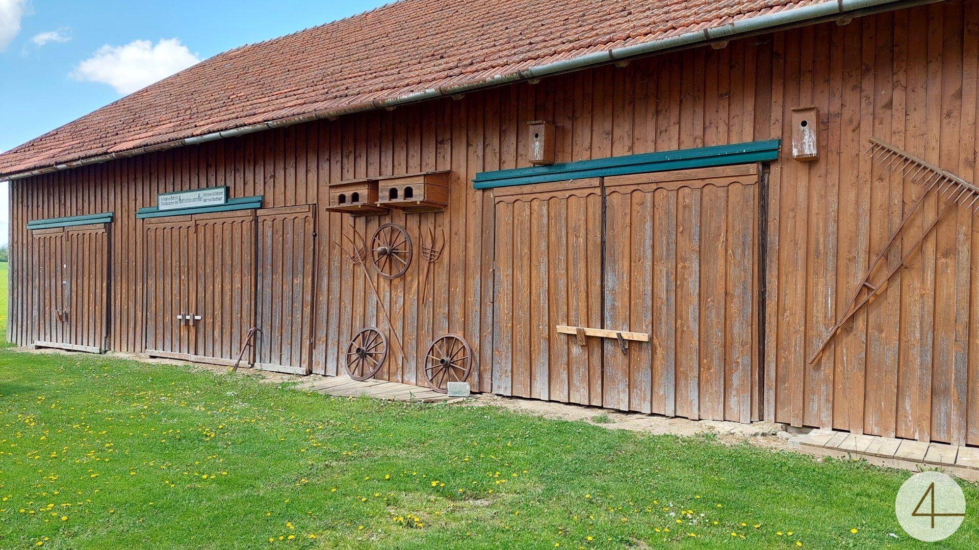 Rustikales Holzgebäude mit großen Holztoren und traditionellen Dekorationen an der Fassade.