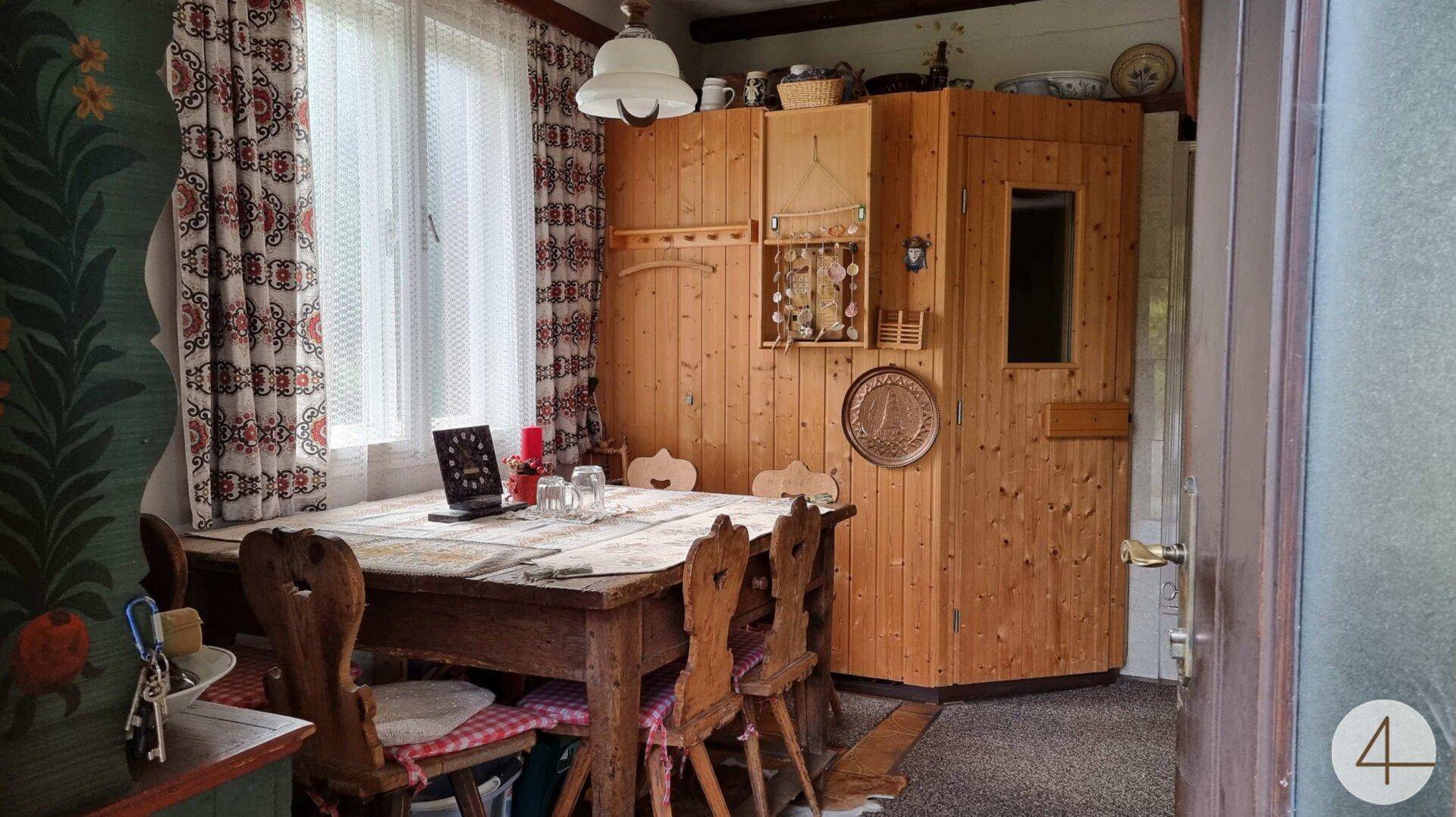 Esszimmer im Landhausstil mit Holztisch, Stühlen und integrierter Sauna.