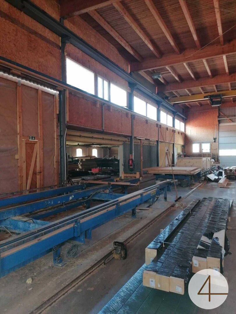 Geräumige Werkshalle mit Maschinen, Holzkonstruktionen und großen Fenstern für Tageslicht.