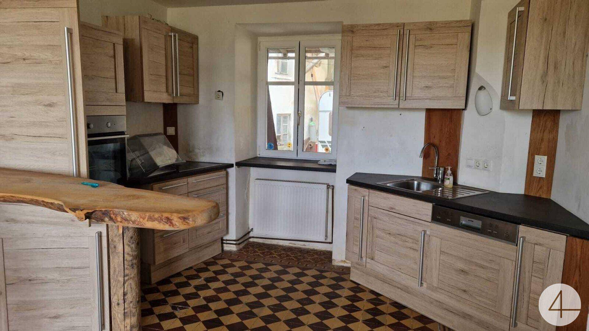 Rustikale Küche mit Holzschränken, kariertem Fliesenboden und einer Arbeitsplatte aus Holz.