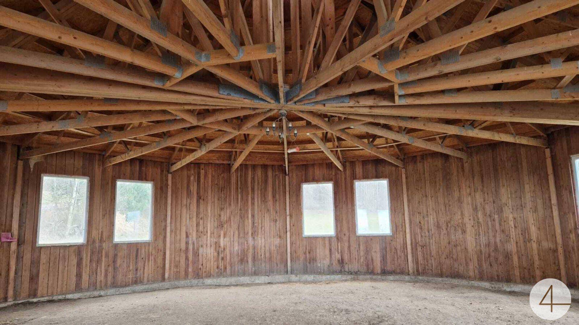 Großer runder Raum mit beeindruckender Holzkonstruktion an der Decke und mehreren Fenstern.
