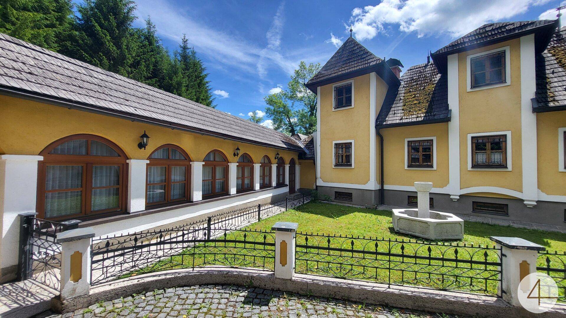 Detailansicht des historischen Anwesens mit einem Brunnen im gepflegten Innenhof.