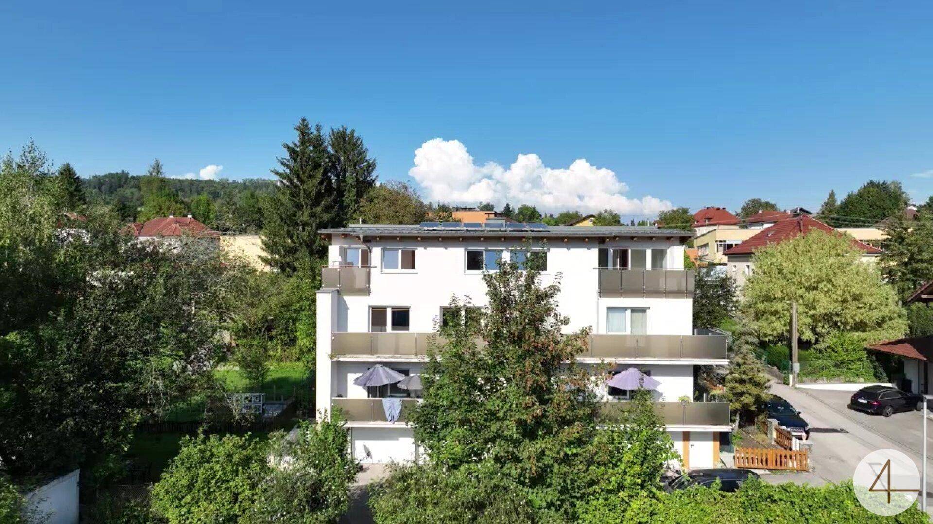 Ansicht der modernen Wohnhausfassade mit Balkonen und Solaranlage auf dem Dach.