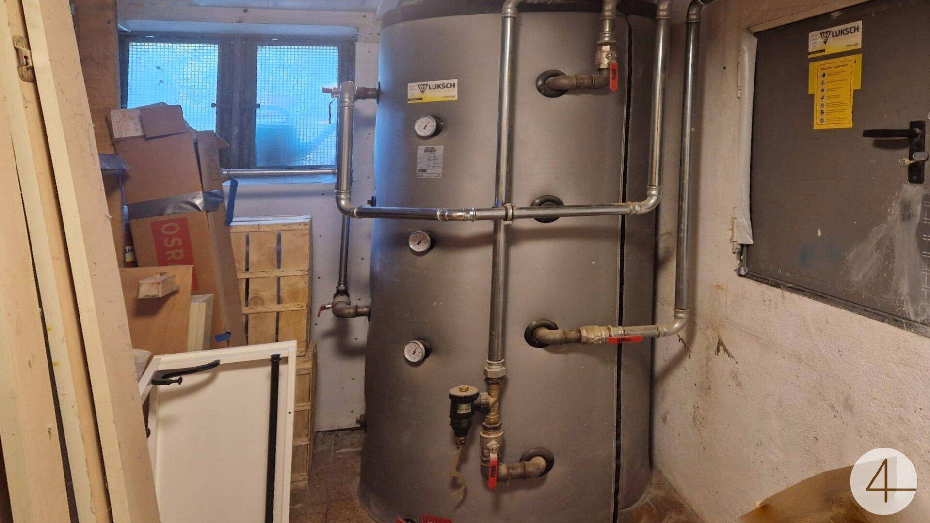 Kellerraum mit großem Warmwasserspeicher und weiteren Installationen, ideal als Technikraum.