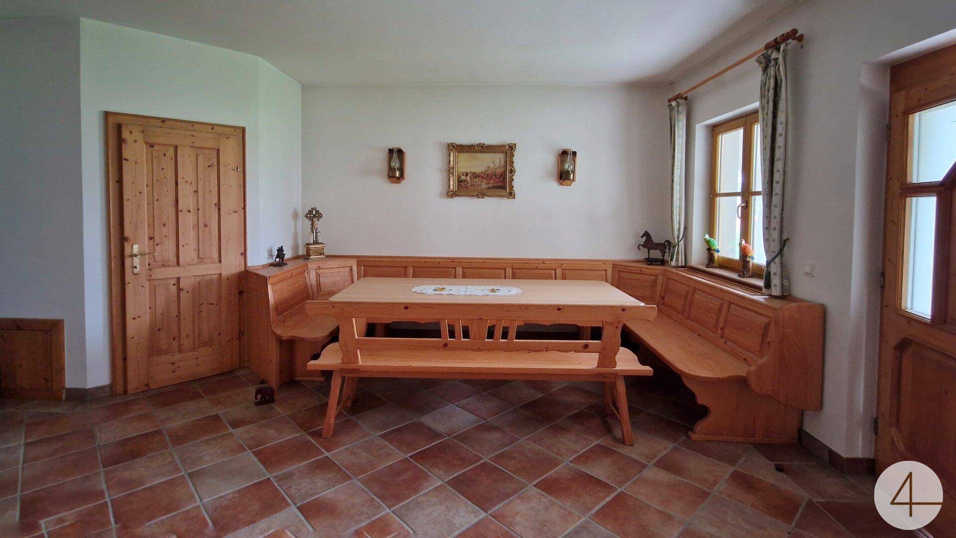 Gemütlicher Essbereich im traditionellen Stil mit Holztisch, Eckbank und Terrakotta-Fliesenboden.