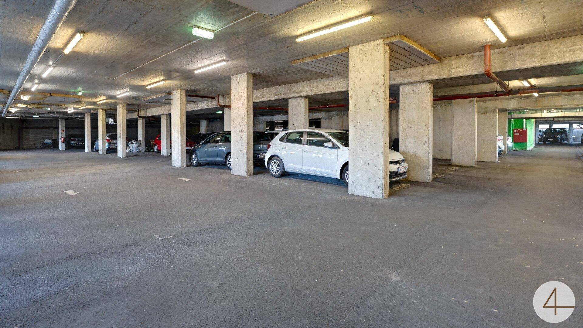 Weitläufige Tiefgarage mit mehreren Stellplätzen und Betonstützen, bietet sicheres Parken.