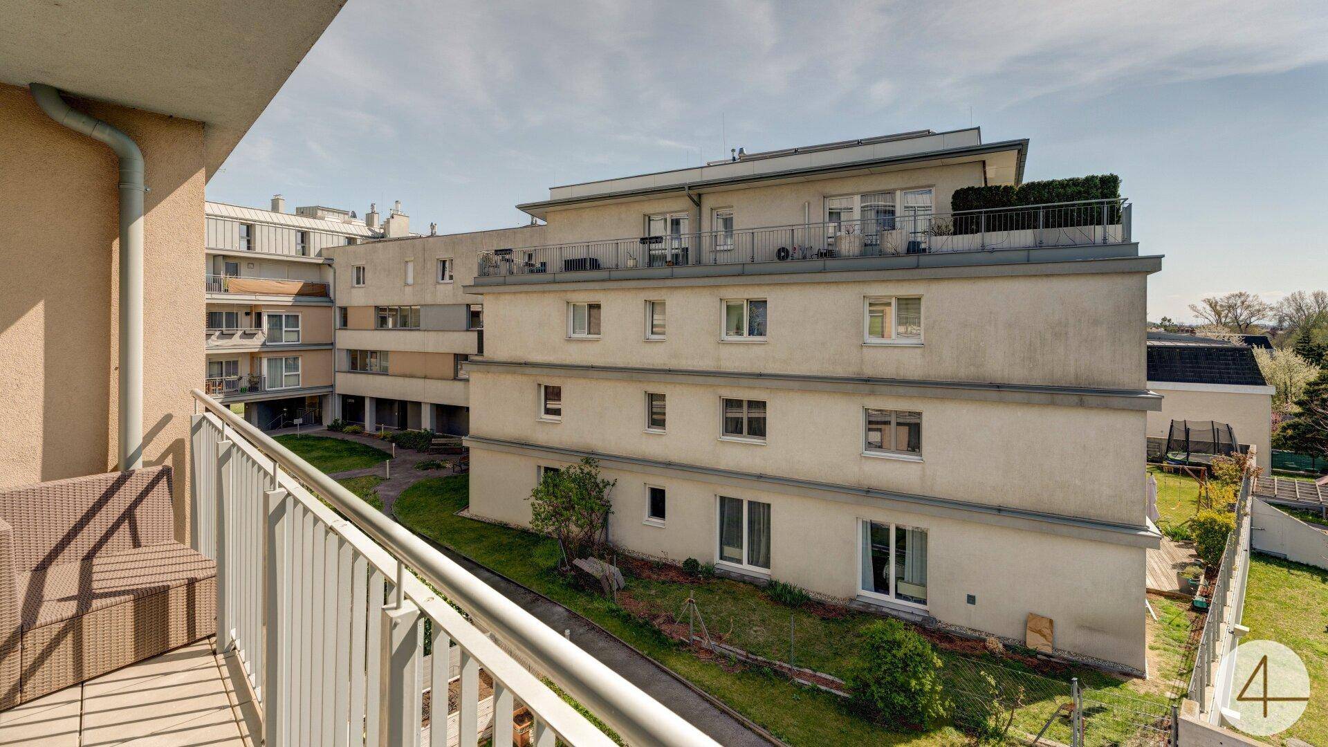 Balkon mit Blick auf den Innenhof und die umliegenden Gebäude der Wohnanlage.