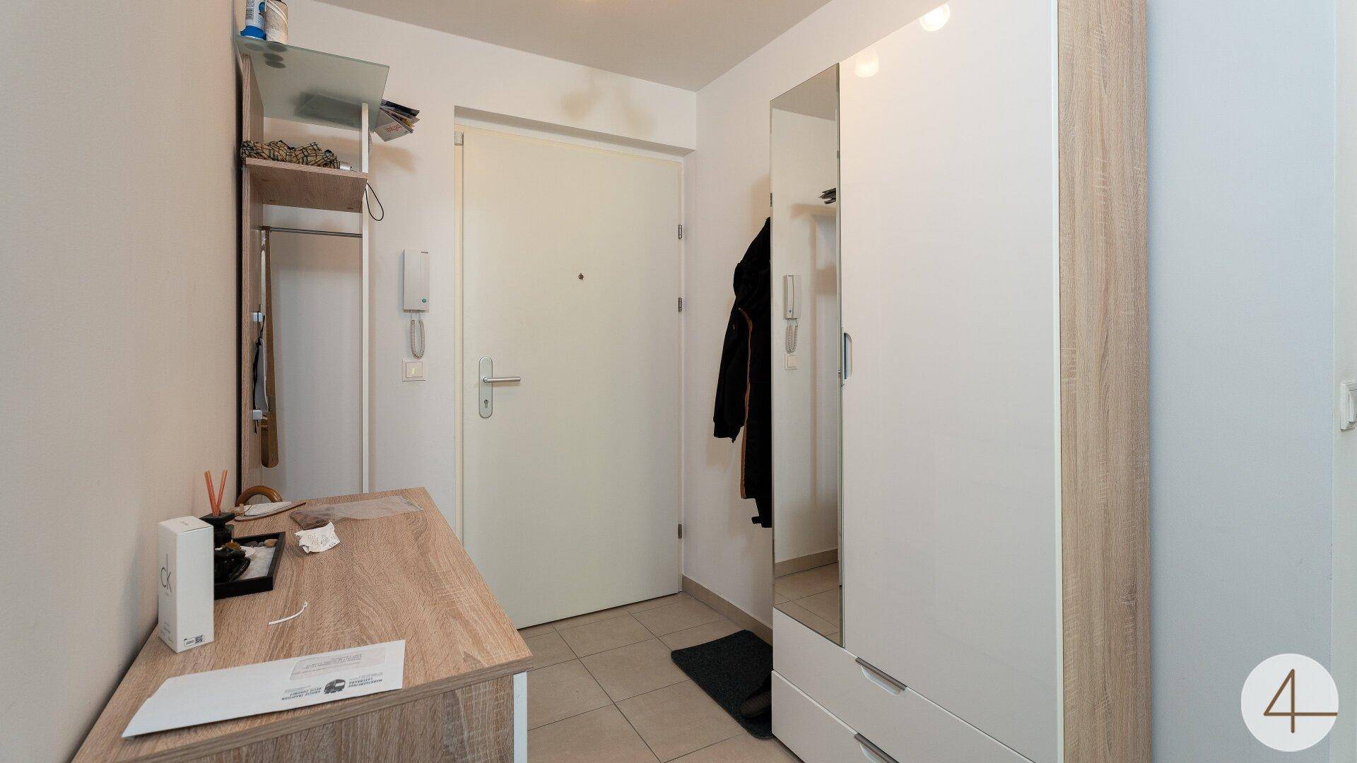 Eingangsbereich mit Fliesenboden, Garderobe und Spiegelschrank, bietet praktischen Empfang.