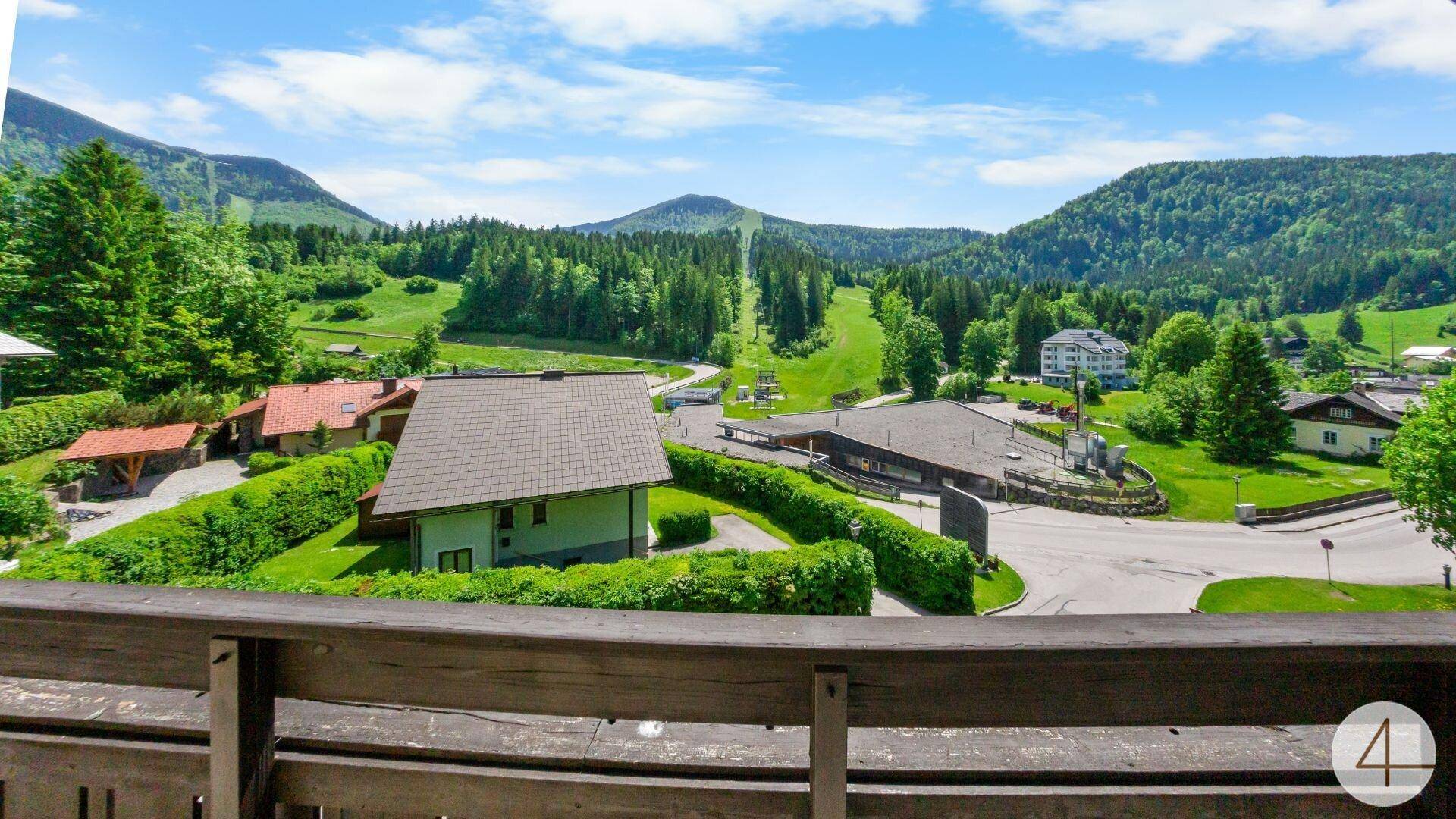 Balkon mit weitem Blick auf die umliegende Berglandschaft und Skipisten.
