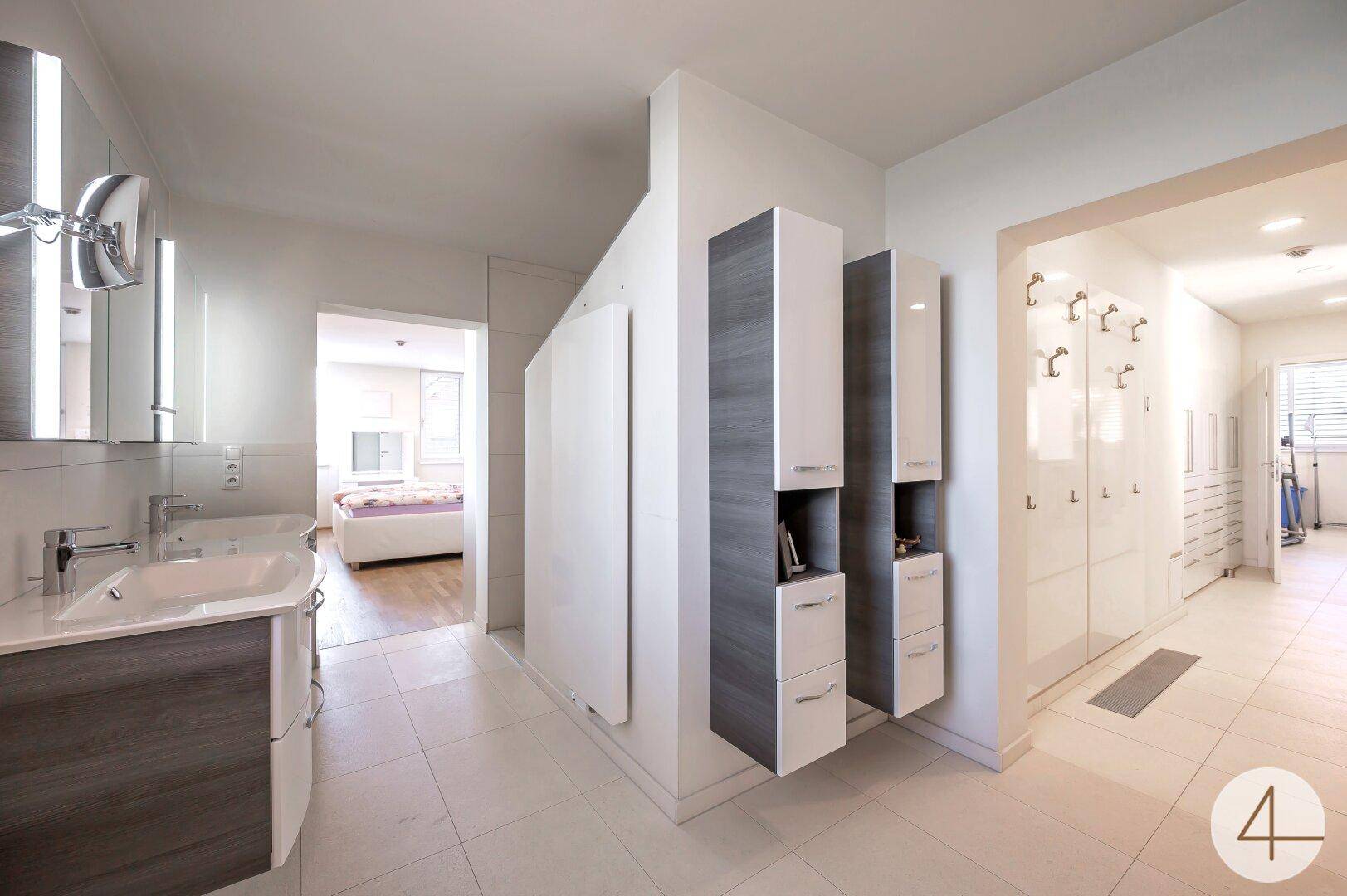 Modernes Badezimmer mit Doppelwaschbecken, Spiegelschrank und eleganten Hängeschränken.