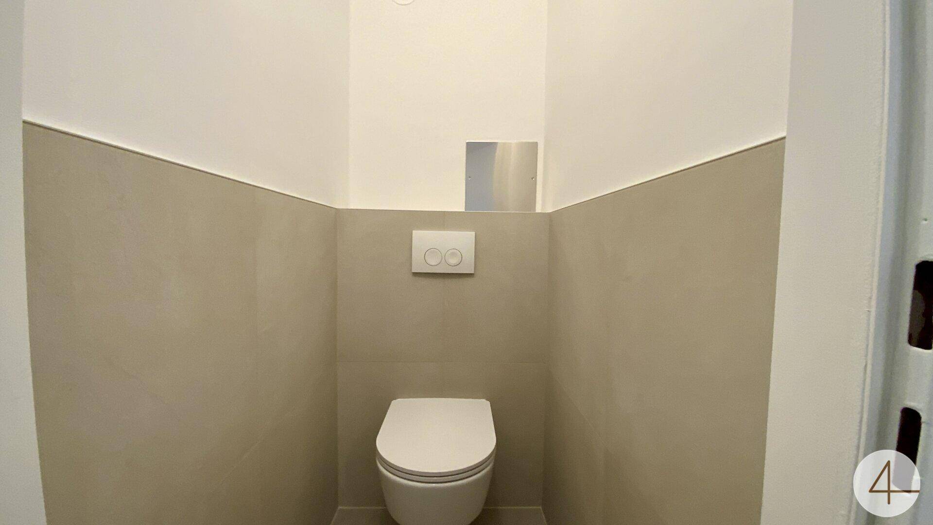 Separates Gäste-WC mit wandhängender Toilette und modernen, zweifarbigen Wänden.