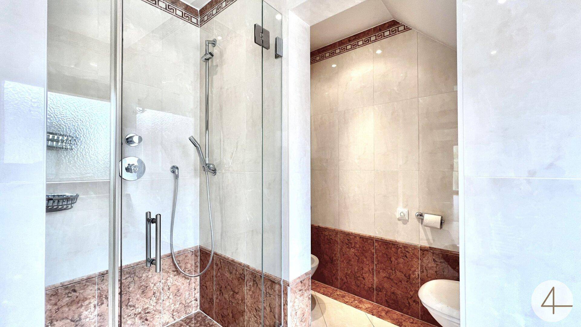 Modernes Badezimmer mit begehbarer Dusche und eleganten Fliesen in Braun- und Beigetönen.