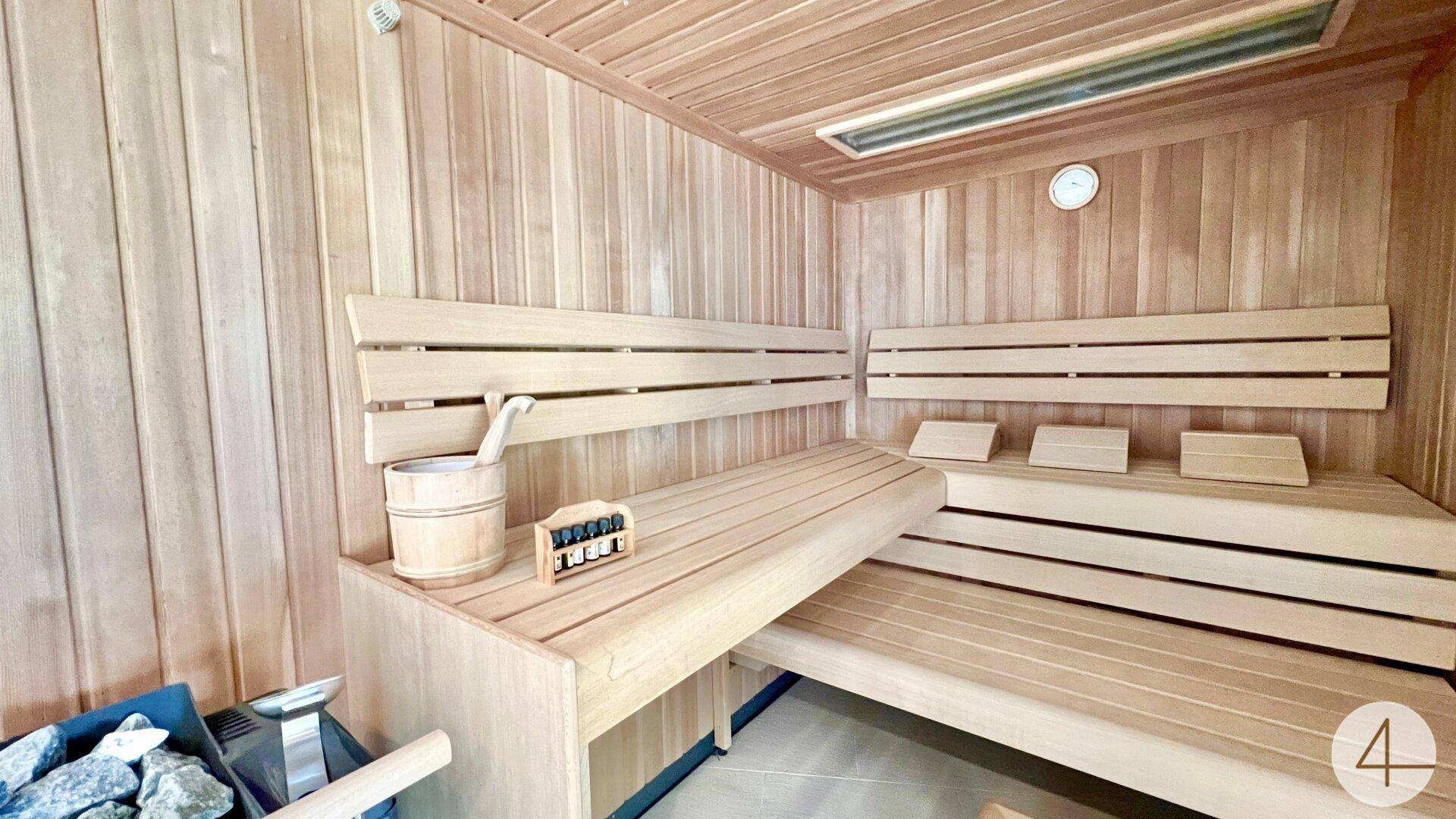 Gemütliche Holzsauna mit Bänken und traditionellem Saunaofen für Entspannung.