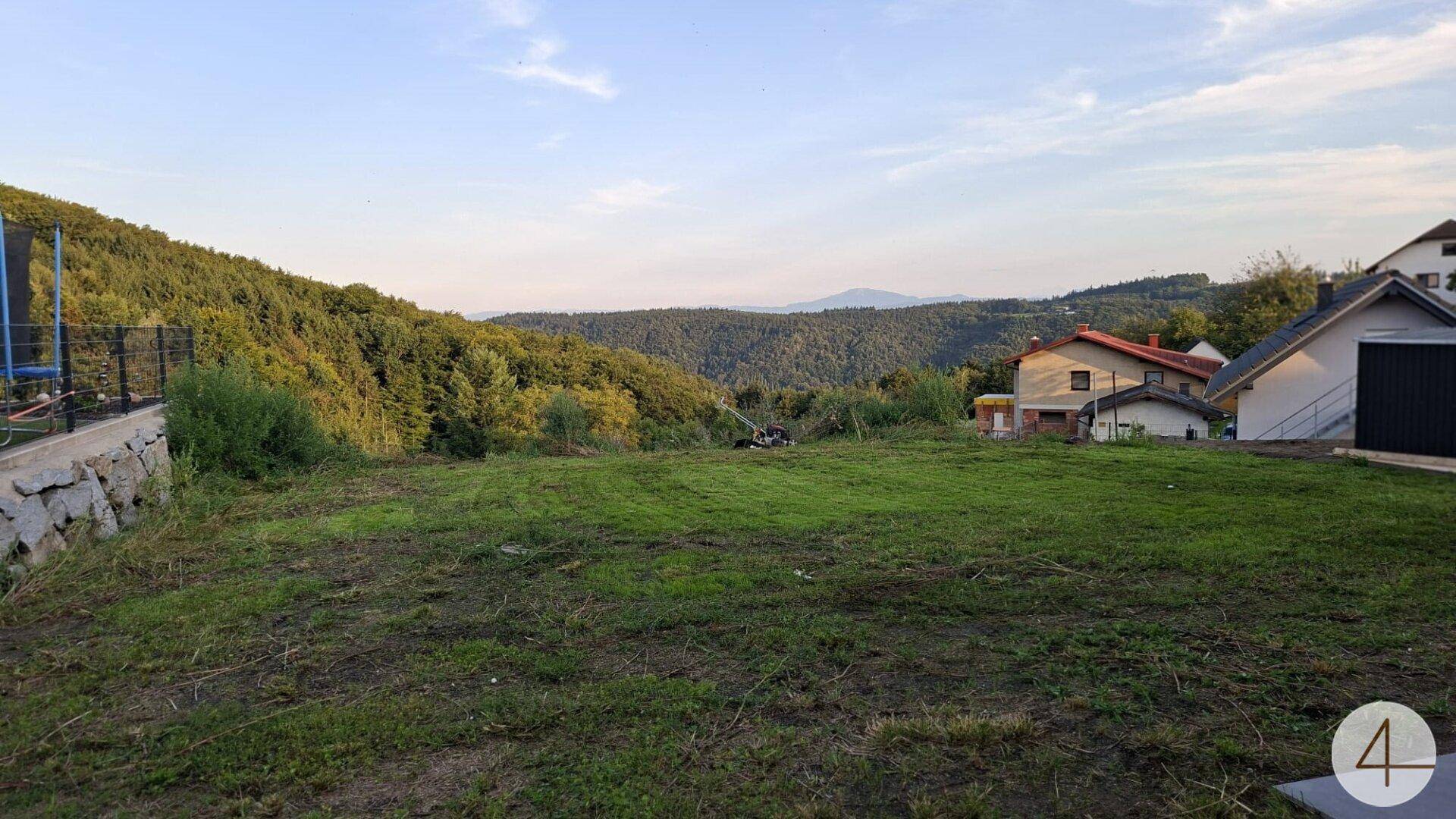 Weitläufiges Grundstück mit Blick auf bewaldete Hügel und die umliegende Landschaft.