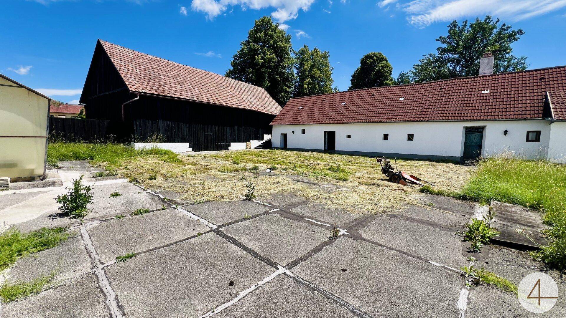 Hofbereich eines ländlichen Anwesens mit Betonflächen und angrenzenden Wirtschaftsgebäuden.