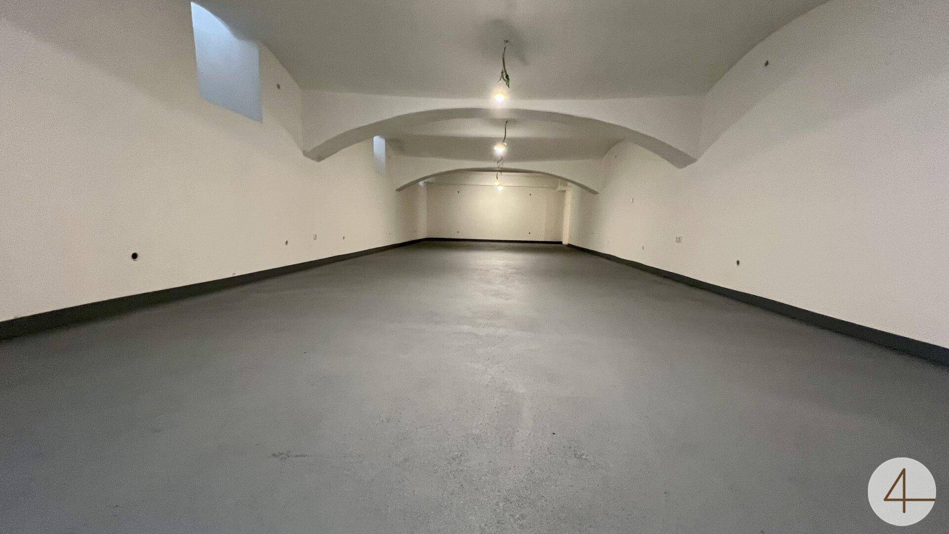 Großer, leerer Raum im Untergeschoss mit gewölbter Decke und robustem Betonboden.