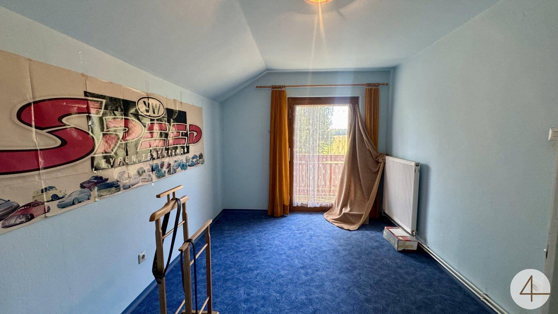 Schlafzimmer mit blauem Teppichboden, hellblauen Wänden und Zugang zu einem Balkon.