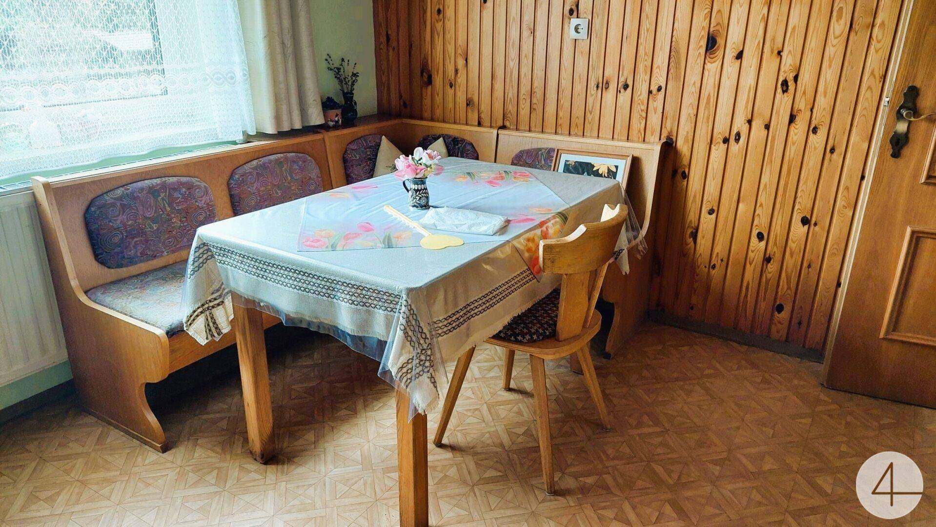 Gemütlicher Essbereich mit Eckbank, Holztäfelung und traditionellem Tisch in der Küche.