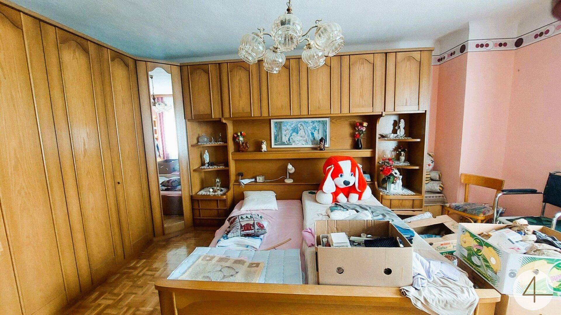 Schlafzimmer mit zwei Betten, Einbauschränken und traditioneller Holzvertäfelung.