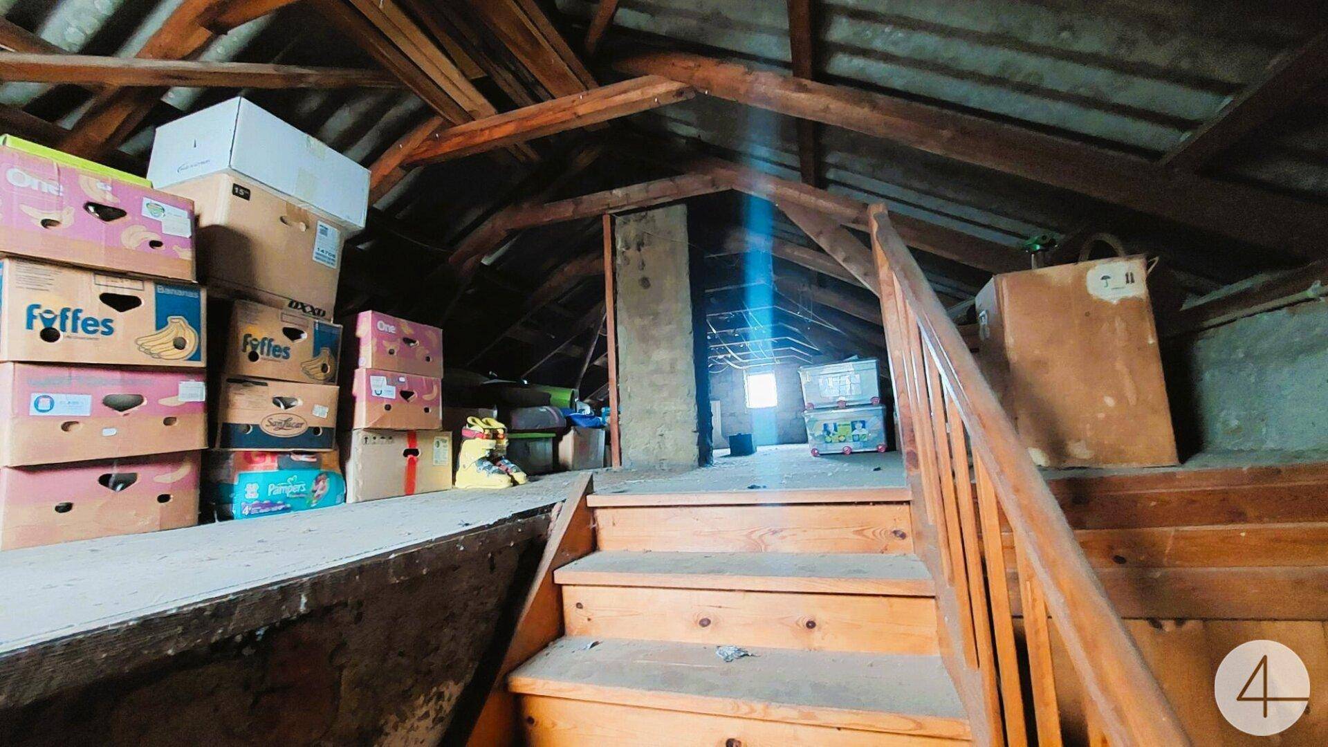 Geräumiger Dachboden mit sichtbaren Holzbalken und gelagerten Kartons.