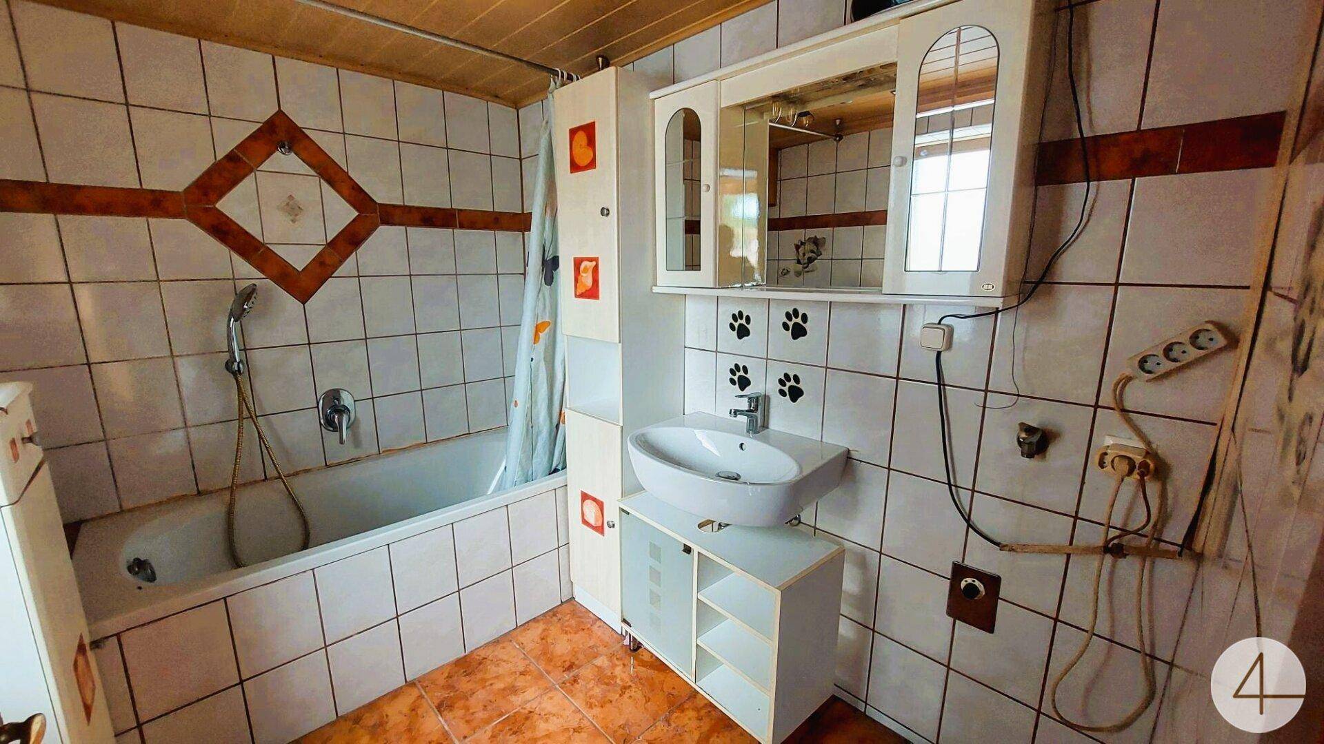 Badezimmer mit Badewanne, Waschbecken und verspielten Fliesenmustern.