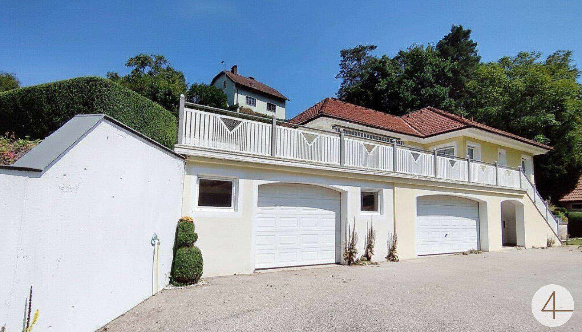 Außenansicht des Hauses mit Doppelgarage und darüberliegender Terrasse.