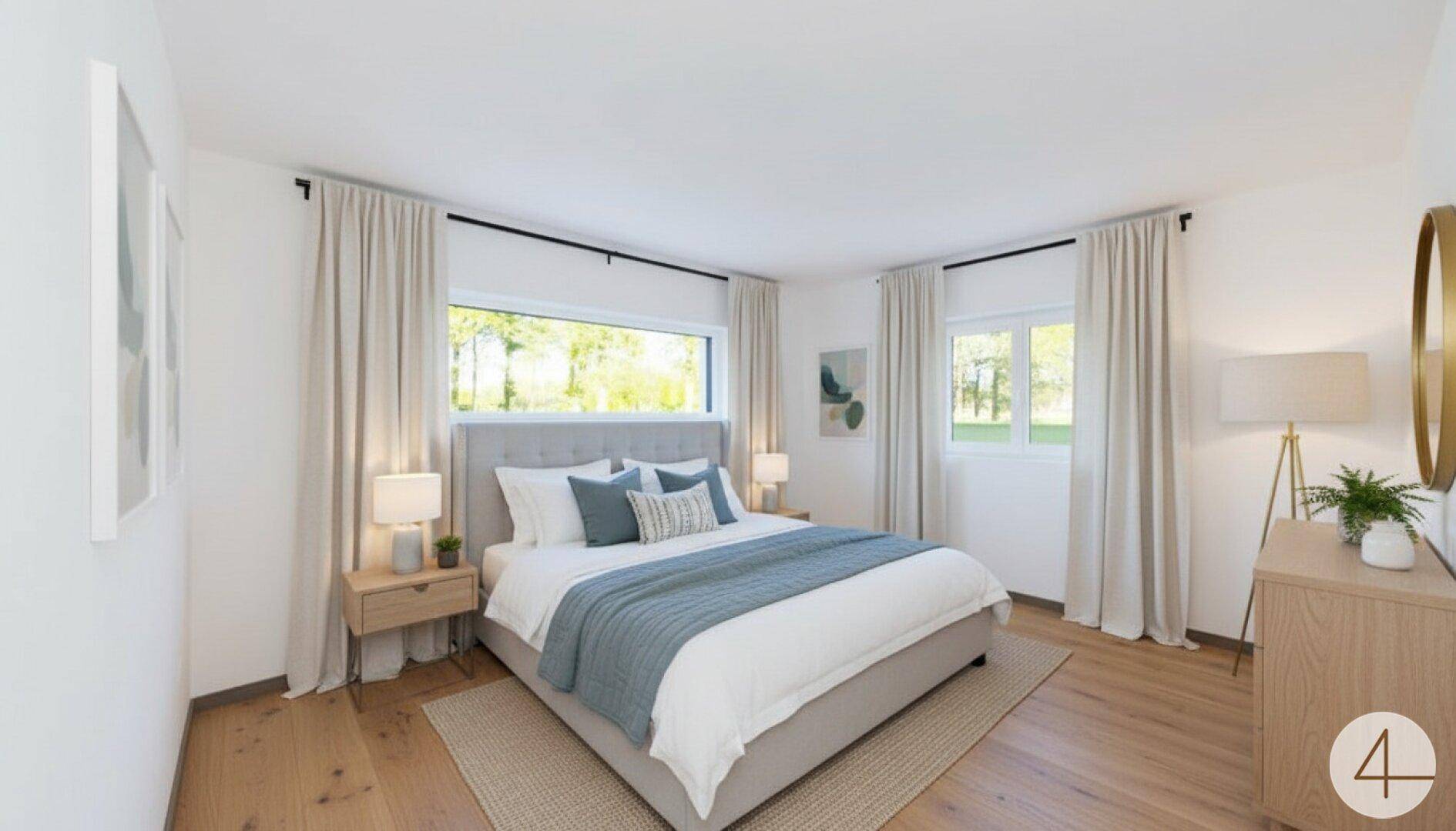 Helles Schlafzimmer mit Holzboden, großem Bett und Blick ins Grüne durch die Fenster.