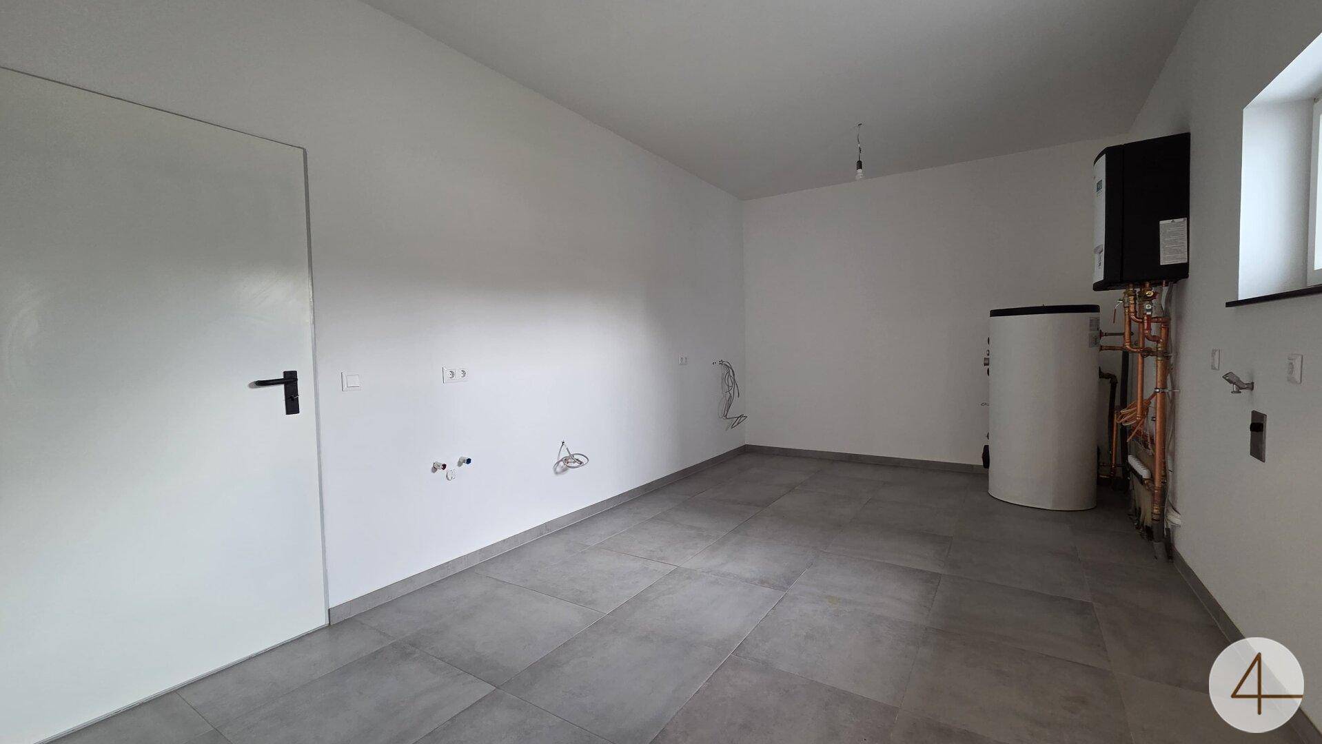 Technikraum mit Heizungsanlage und Anschlüssen, bereit für die weitere Ausstattung.