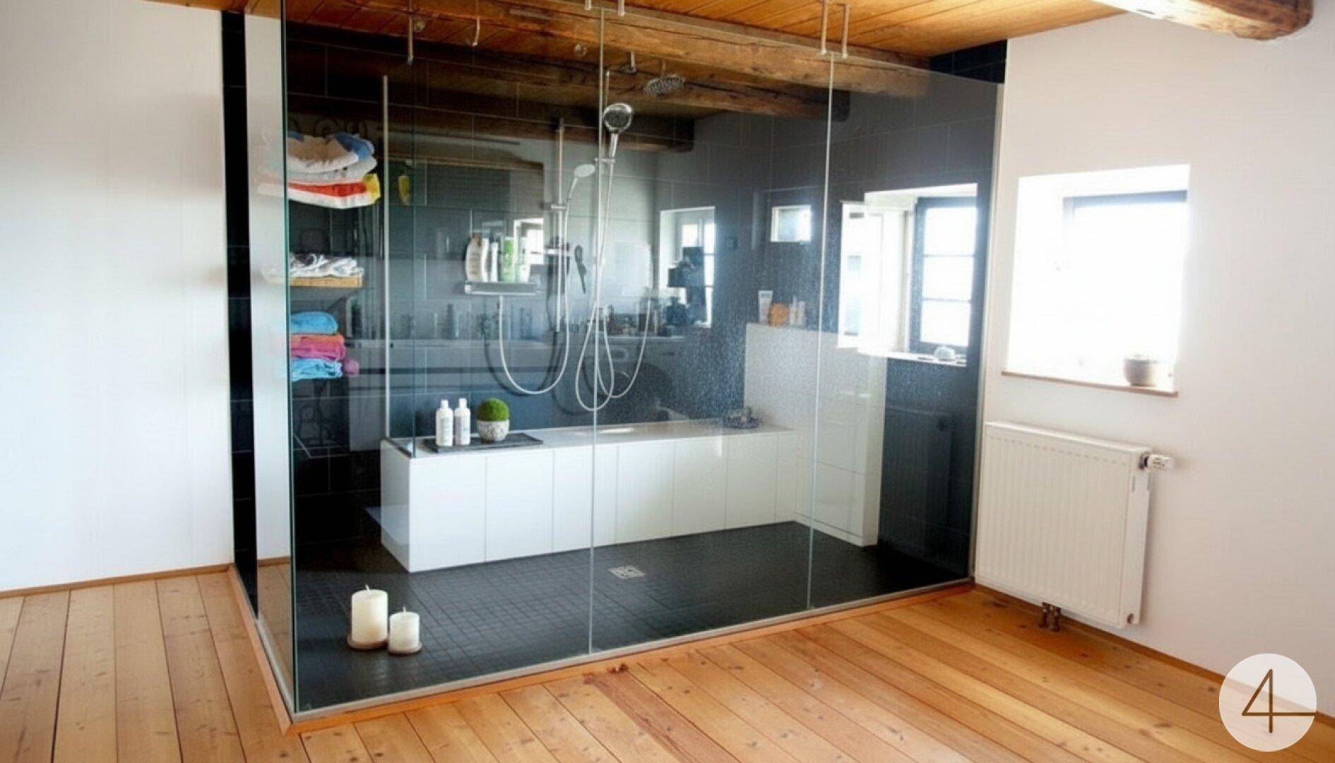 Modernes Badezimmer mit großer begehbarer Dusche, Holzboden und sichtbaren Holzbalken.