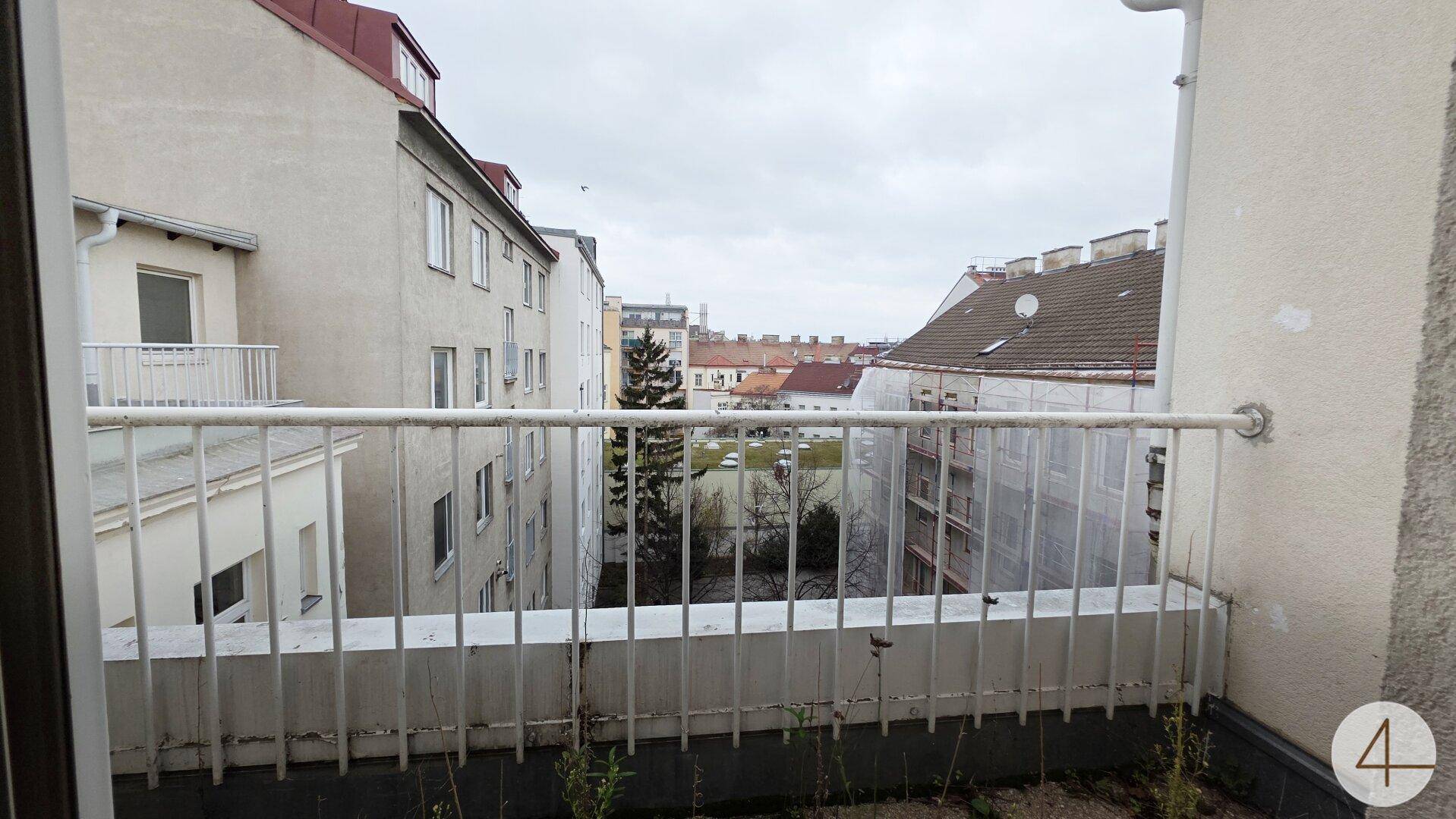 Balkon mit Blick auf die umliegenden Gebäude und den Innenhof.