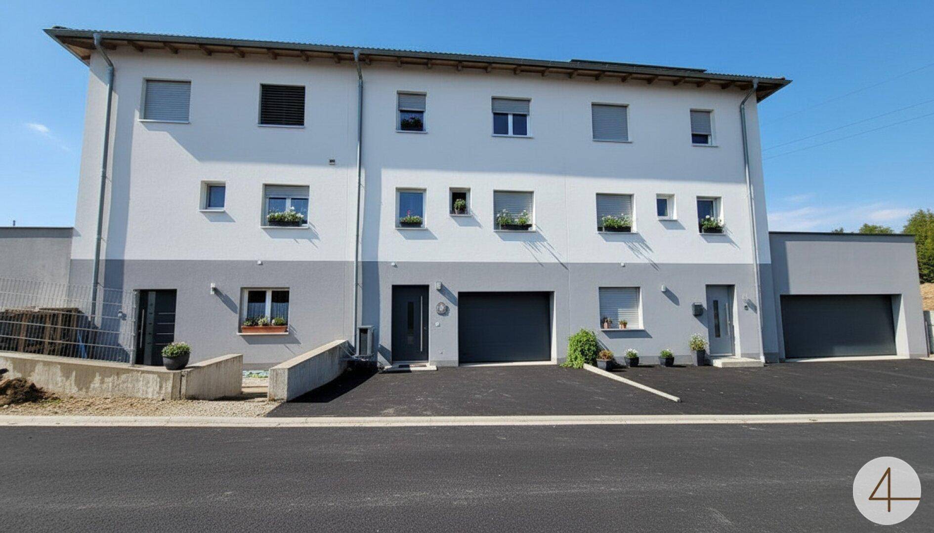 Moderne Wohnanlage mit mehreren Wohneinheiten und integrierten Garagen.