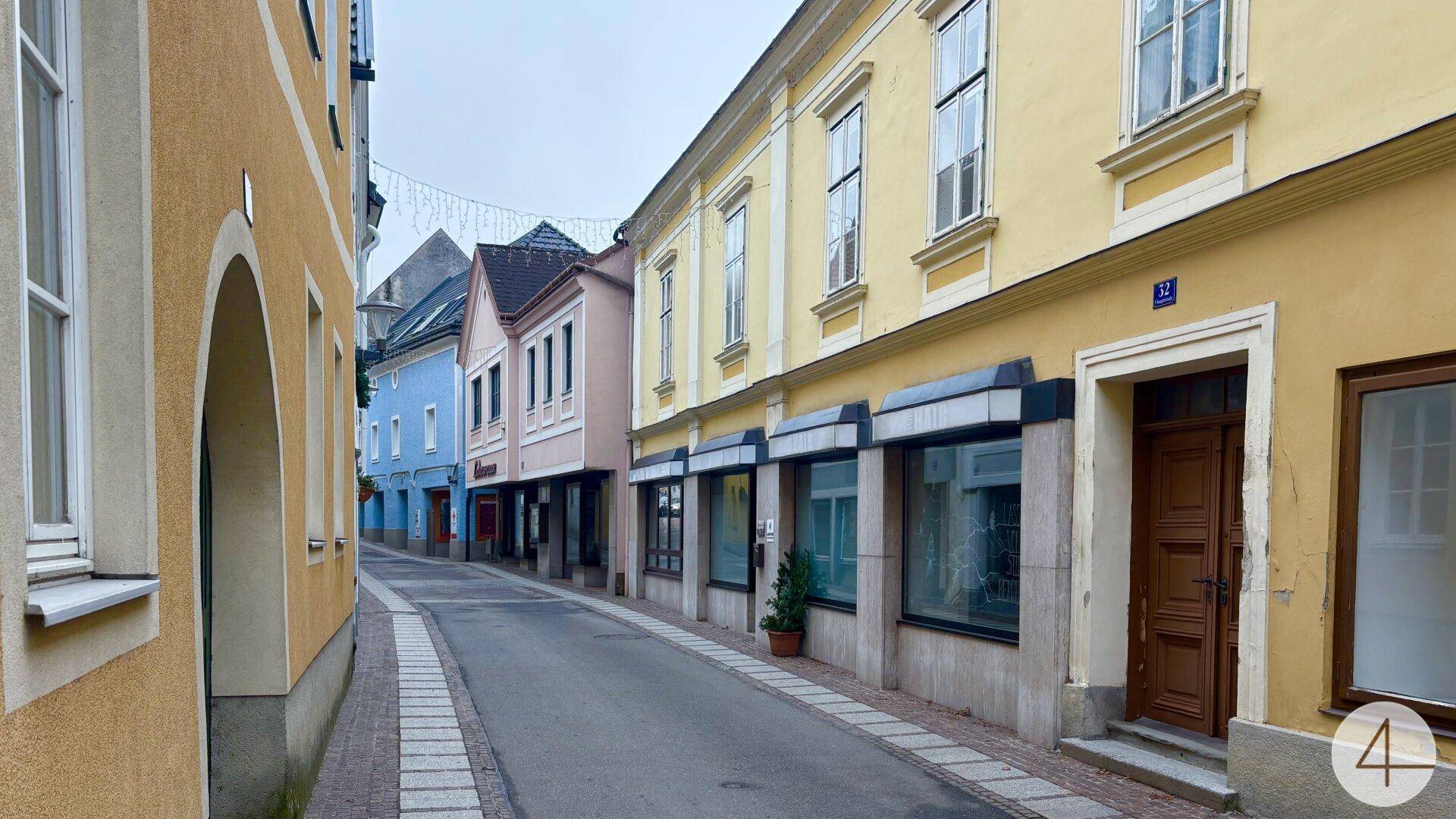 Malerische Gasse mit farbenfrohen historischen Gebäuden und kleinen Geschäften.