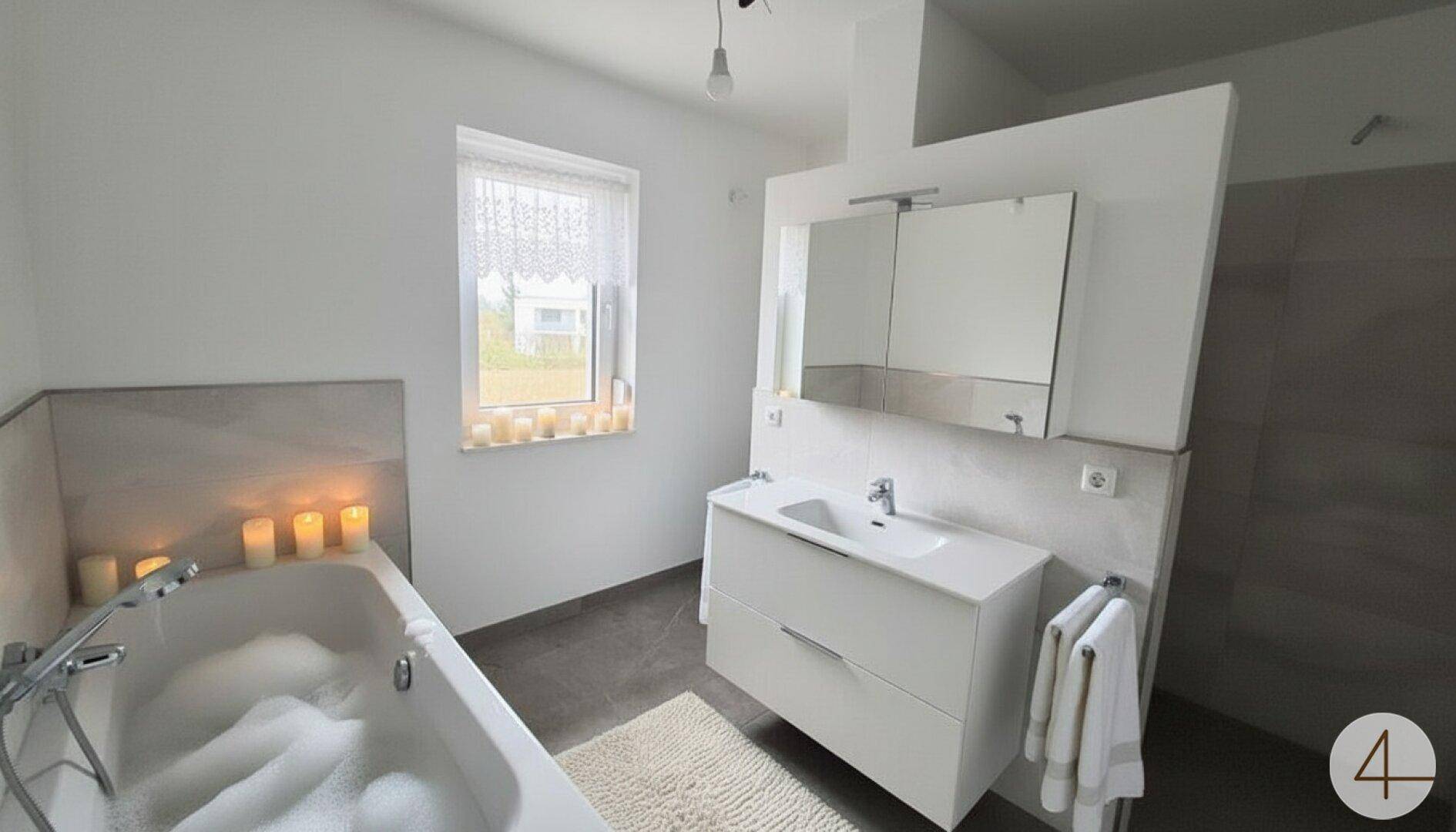 Modernes Badezimmer mit Badewanne, Einzelwaschbecken und Fenster für Tageslicht.