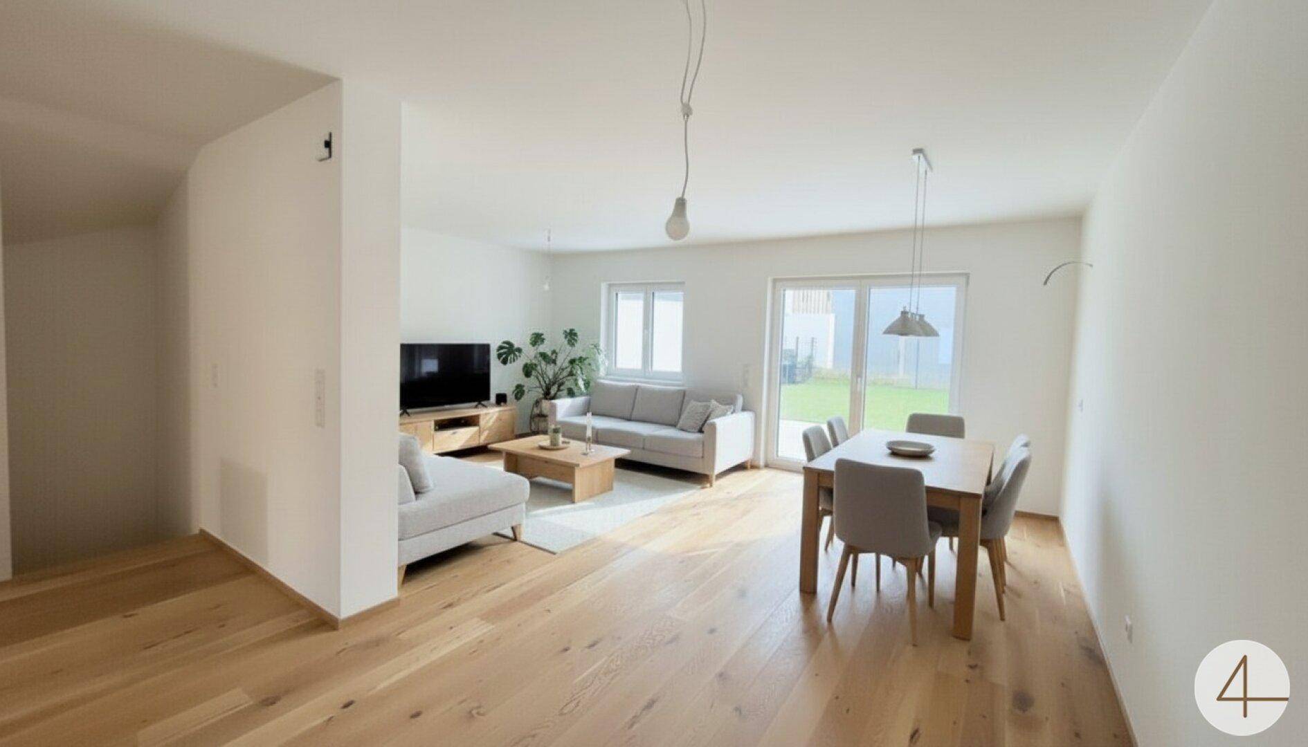 Geräumiger Wohn- und Essbereich mit hellem Holzboden und großen Fenstern zum Garten.