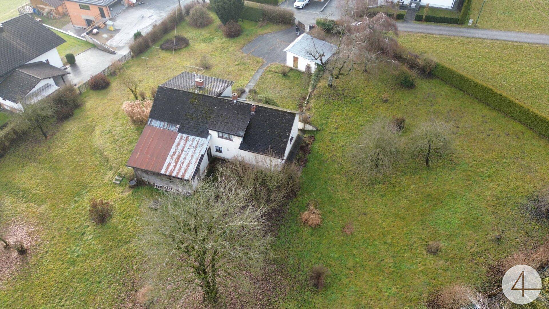 Übersicht aus der Vogelperspektive auf das Wohnhaus mit weitläufigem Grundstück und umliegender Natur.